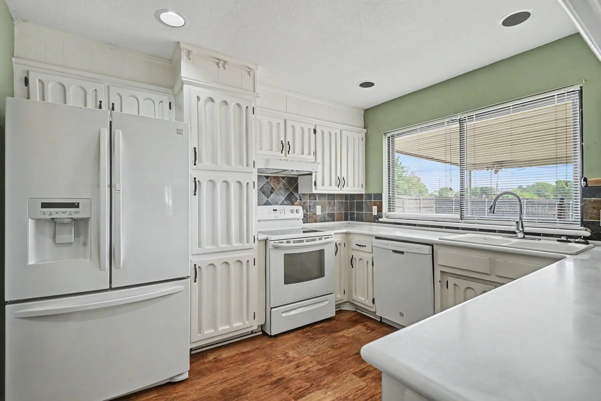 Kitchen featuring white cabinetry, wood-finish flooring, recessed lighting, and a white countertop