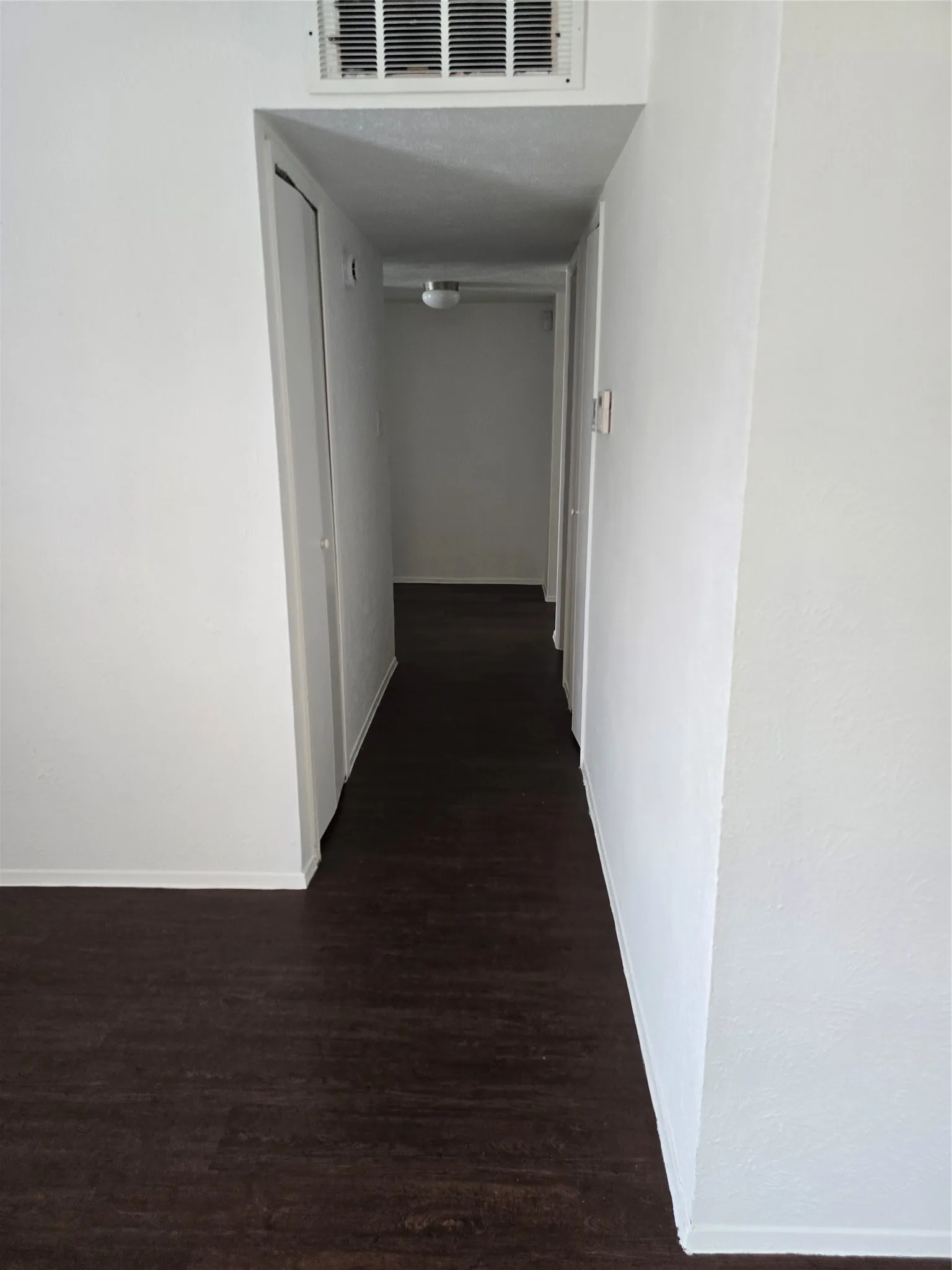 Hallway from living. Two smaller bedrooms are on the left.  Hall bath and master bedroom are on the right.