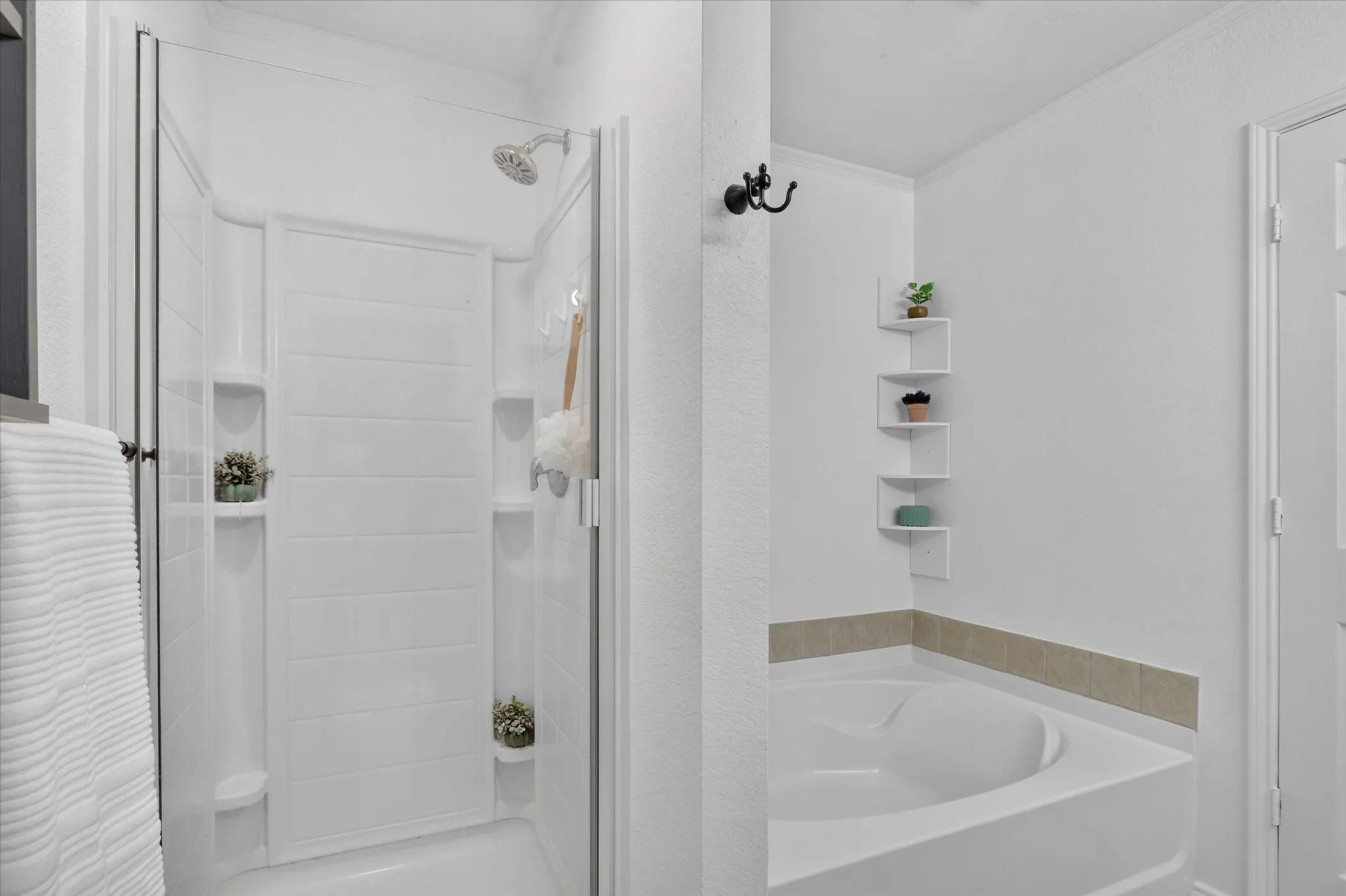 Shower enclosure with glass paneling, a built-in shower caddy, and a fixed shower head