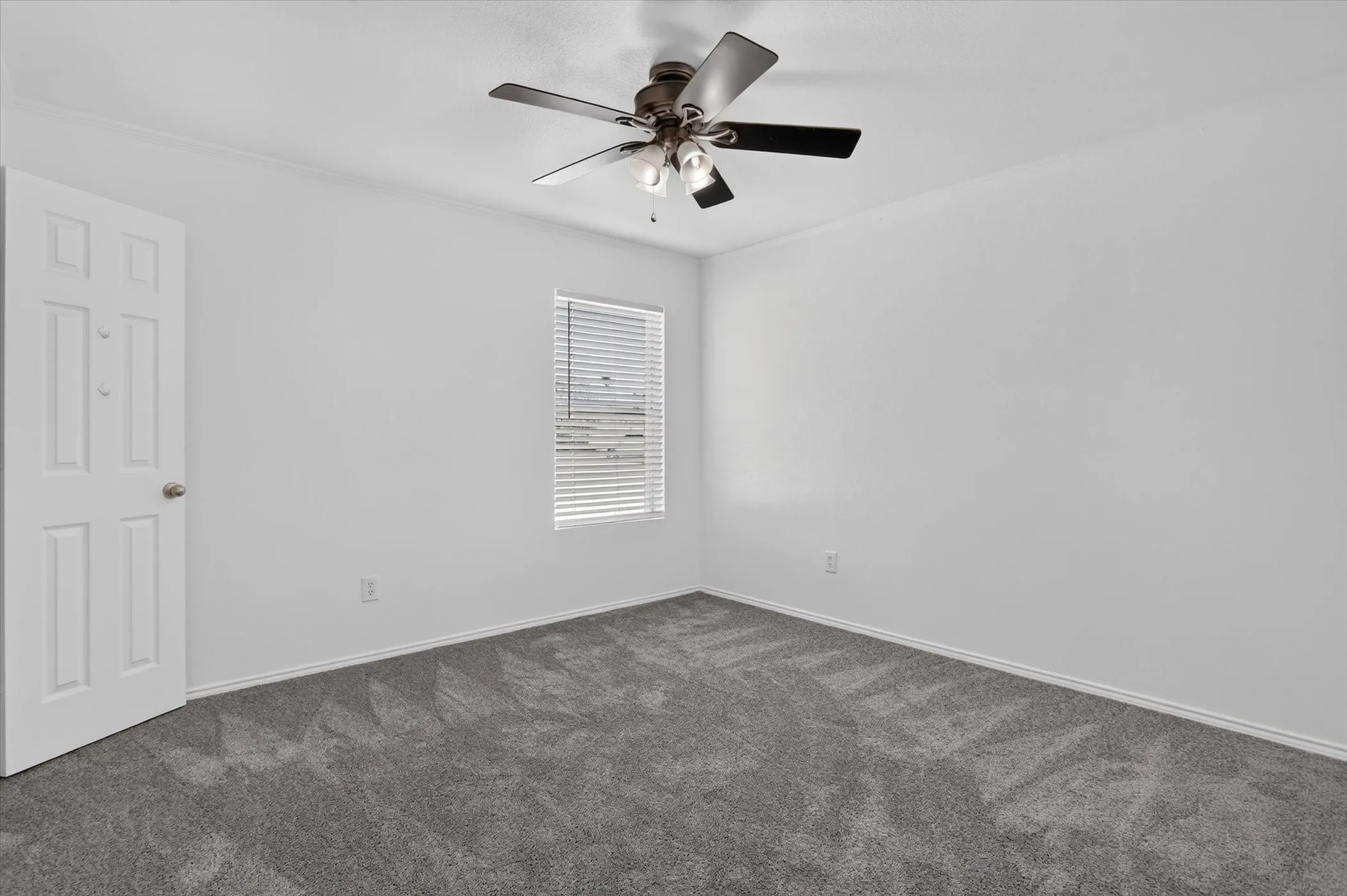 Neutral wall paint with carpet flooring, a ceiling fan with integrated lighting, and a window with horizontal blinds