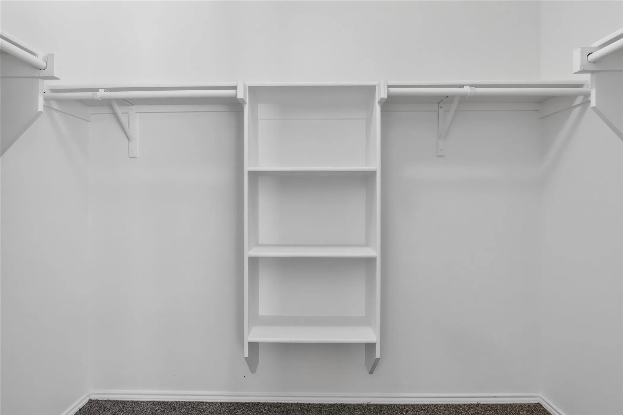 Built-in shelving unit with multiple storage rods and carpeted flooring