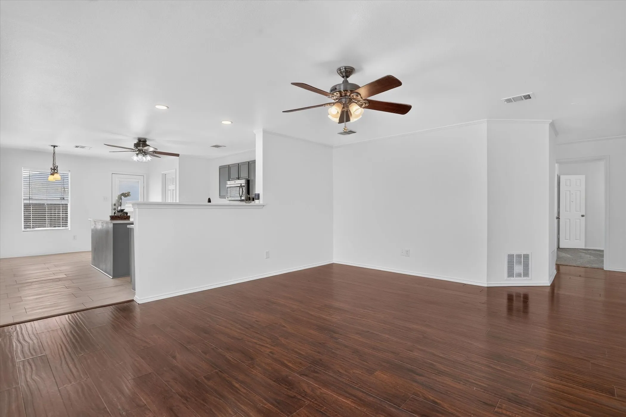 Wood-finish flooring throughout, bright white walls, and a recessed lighting fixture