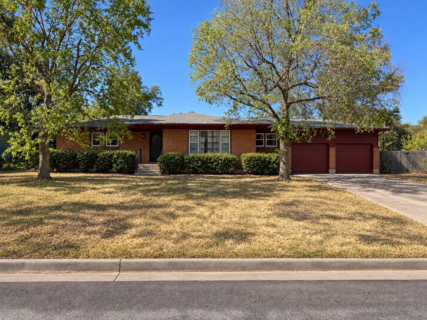 Photo has been edited to clean up / cut back the landscaping in front of the home.