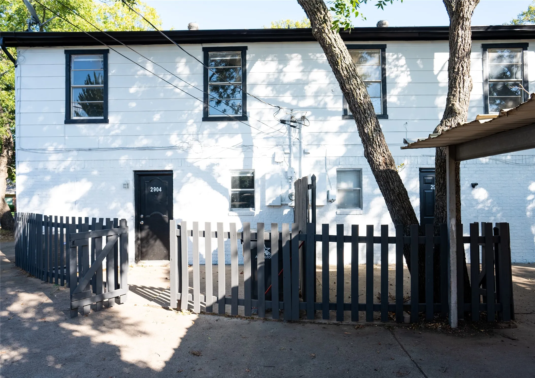 Two-story exterior with white siding and black trim windows