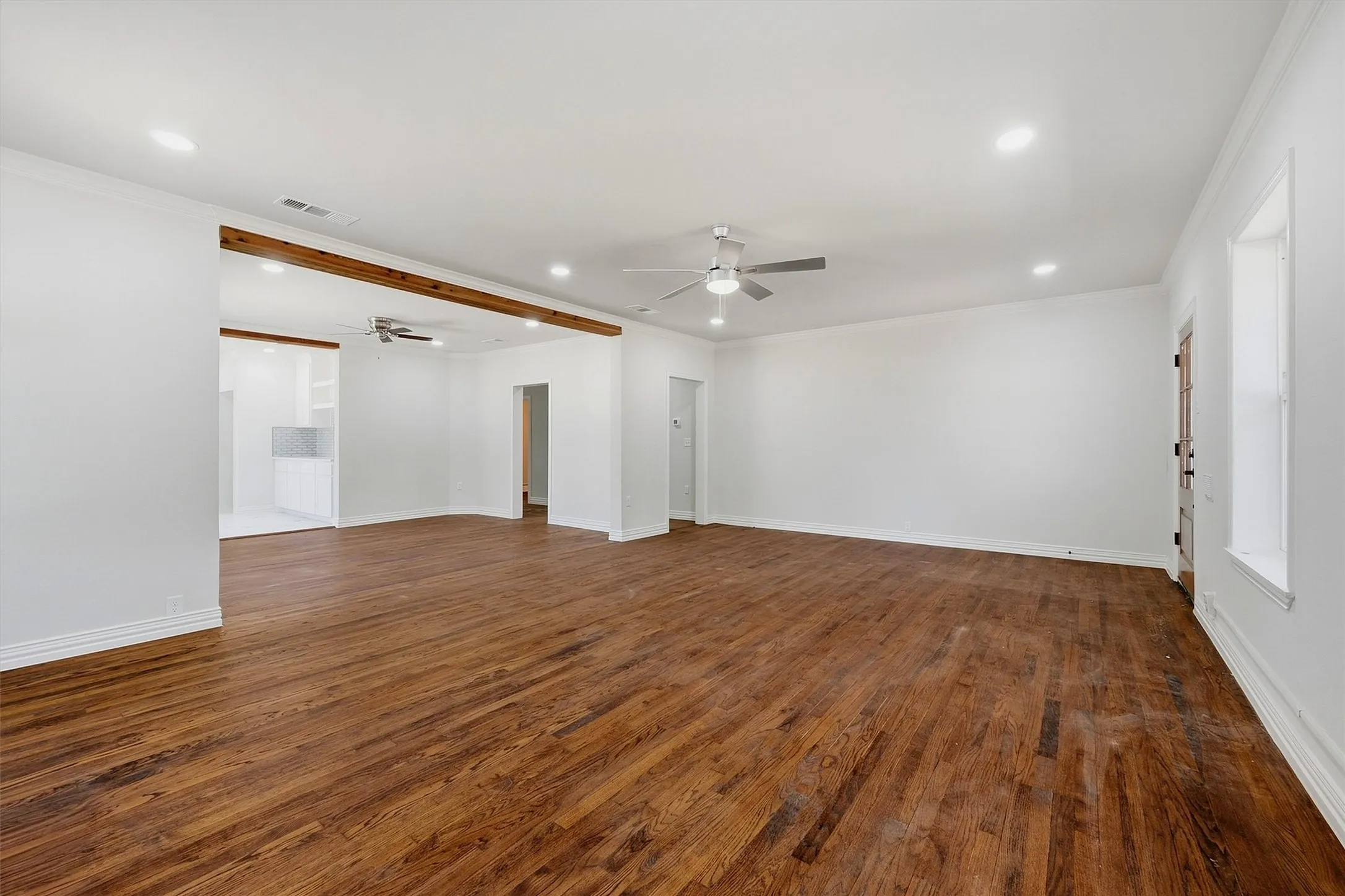 Spacious room featuring wood-finish flooring, recessed lighting, and a ceiling fan