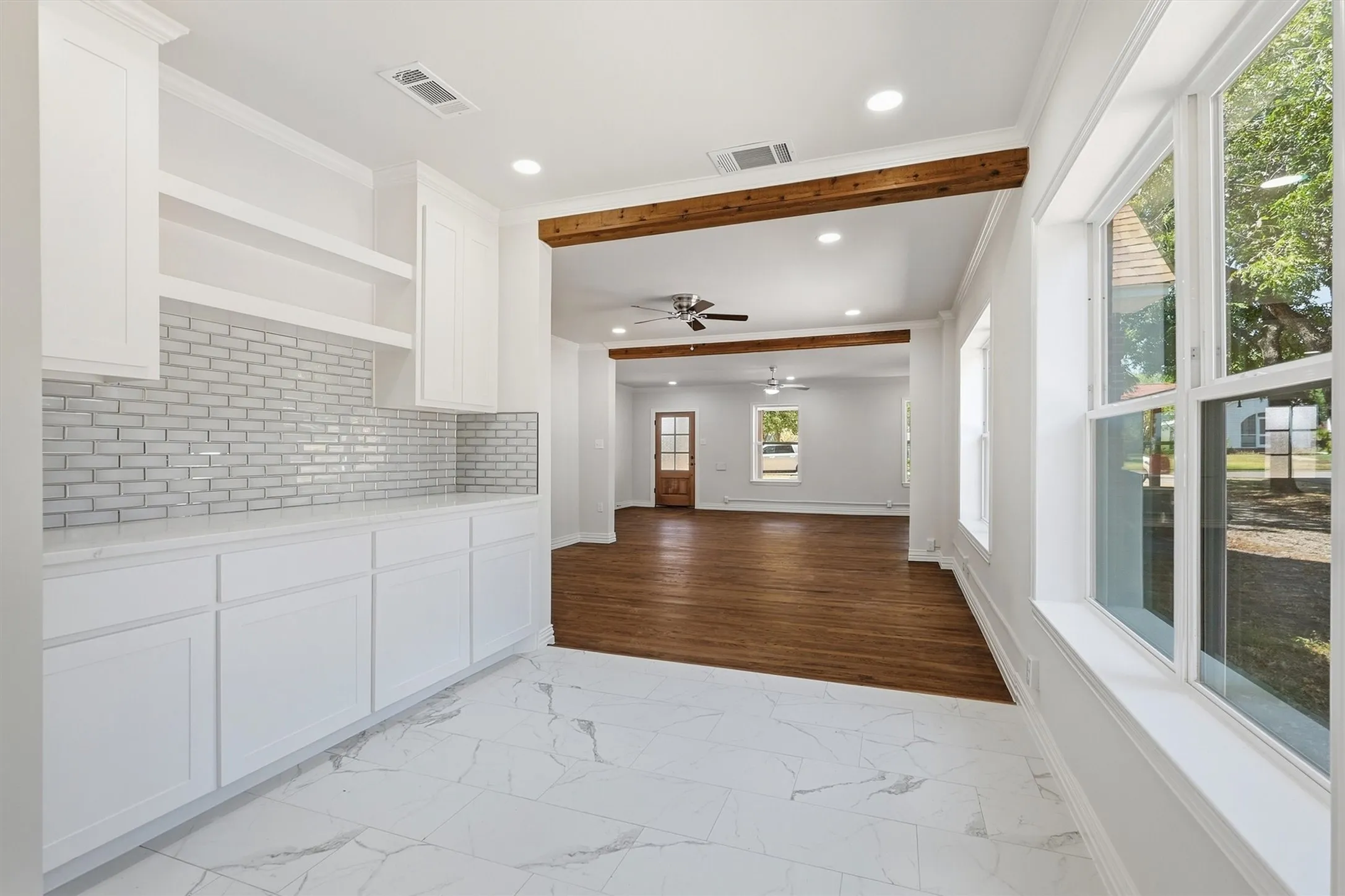 White cabinetry with open shelving and subway tile backsplash