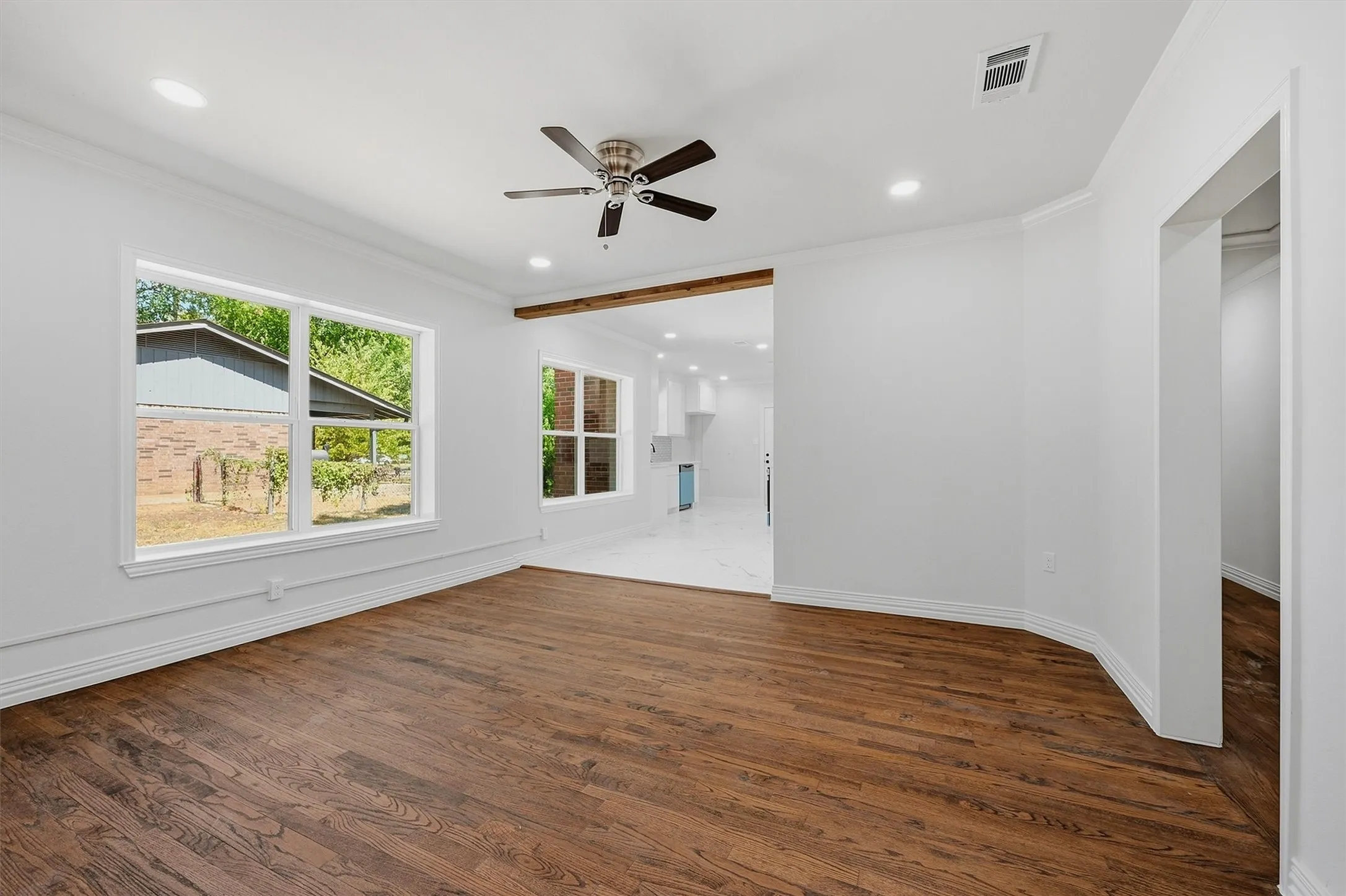 Spacious room featuring wood-finish flooring, recessed lighting, and a ceiling fan