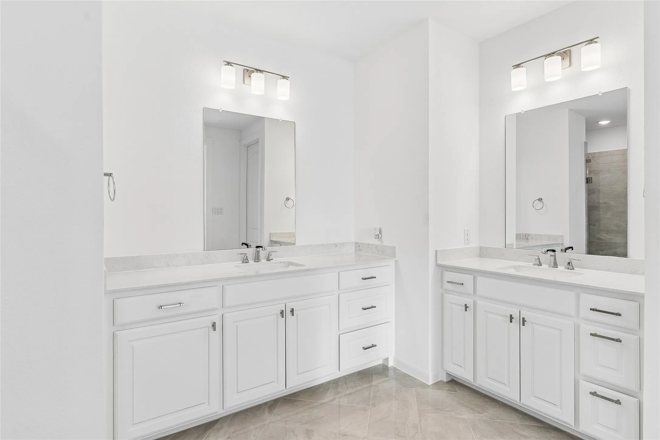 Dual vanity sinks with white cabinetry and stone countertops