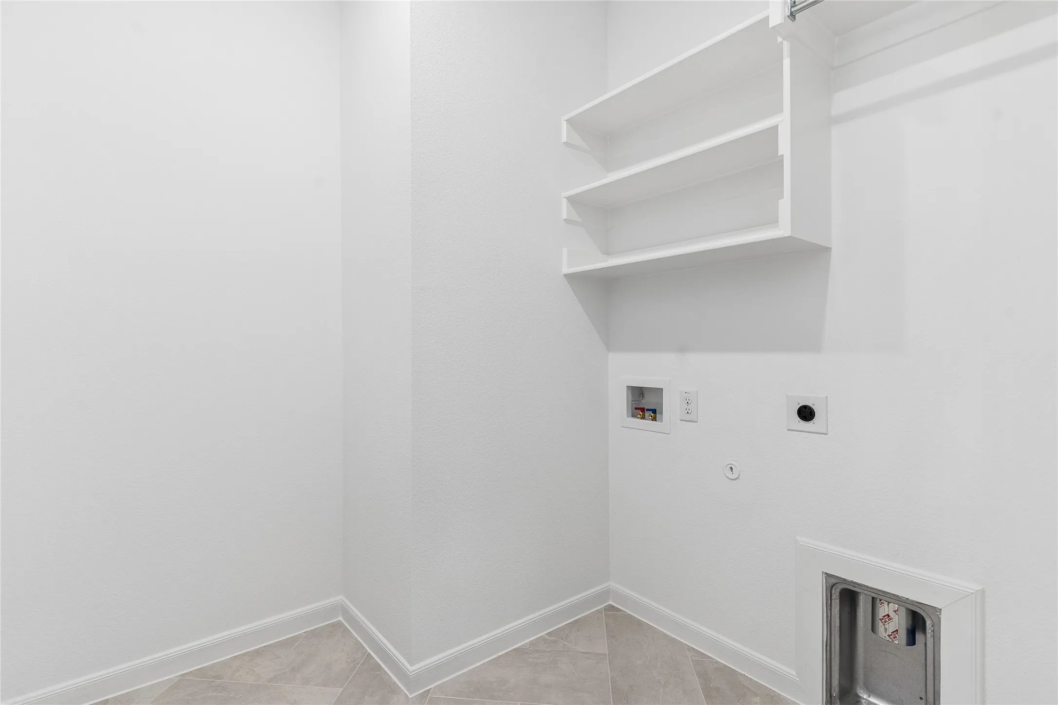 Built-in shelving, tile flooring, and utility hookups