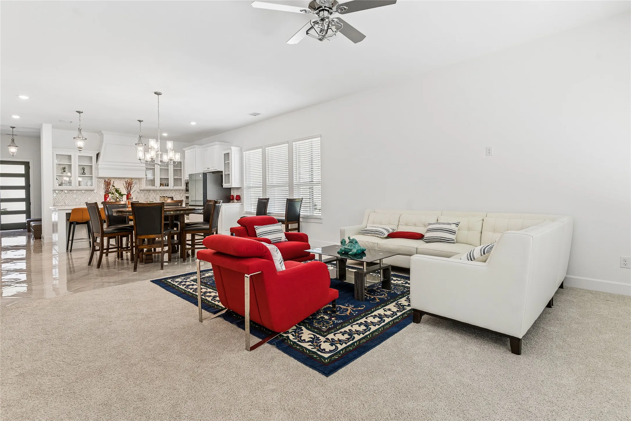 Open-concept living space with light-toned carpeting and tile flooring
