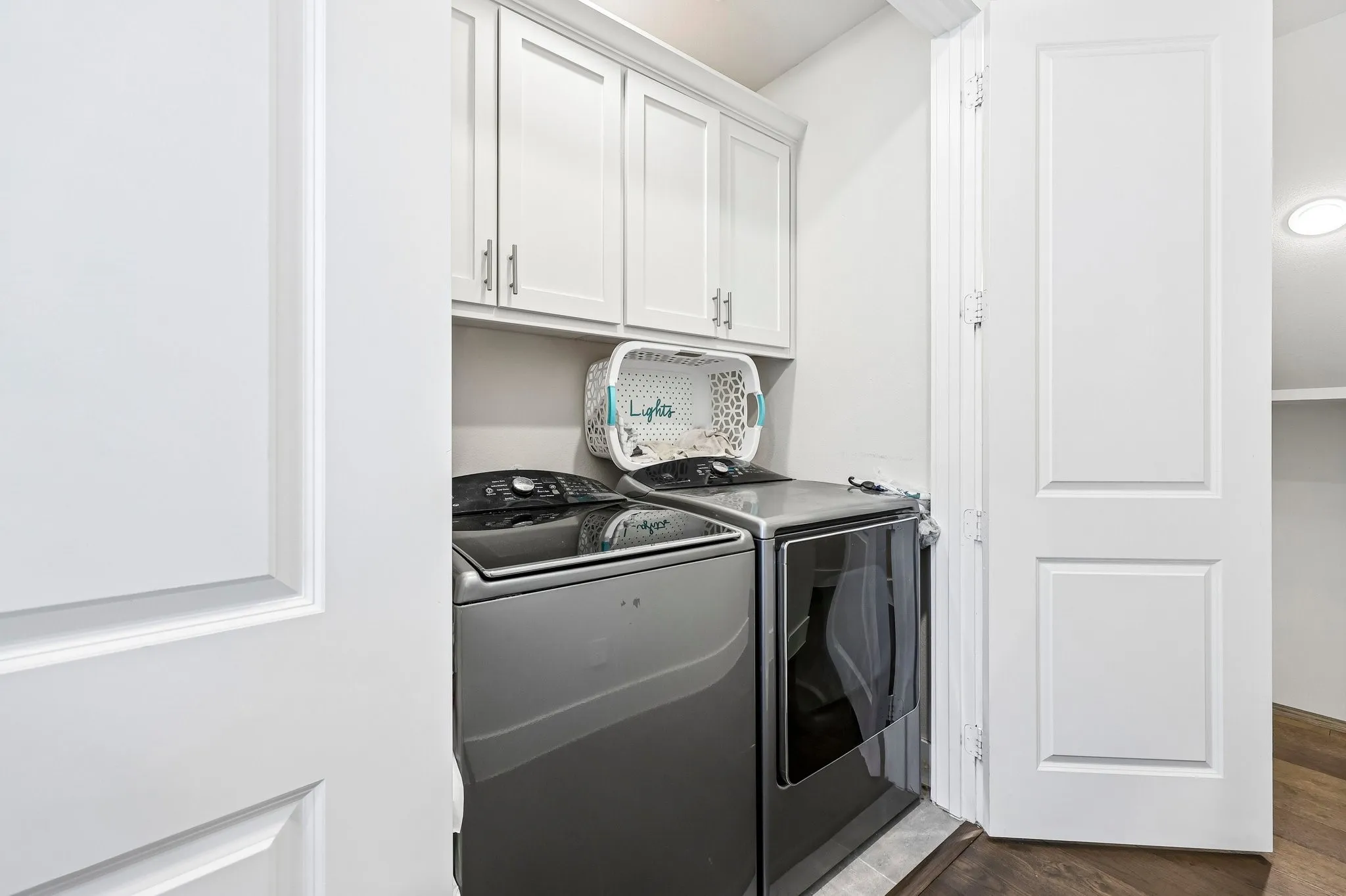 Full Size Washer and Dryer Area with Upper Cabinets for Storage
