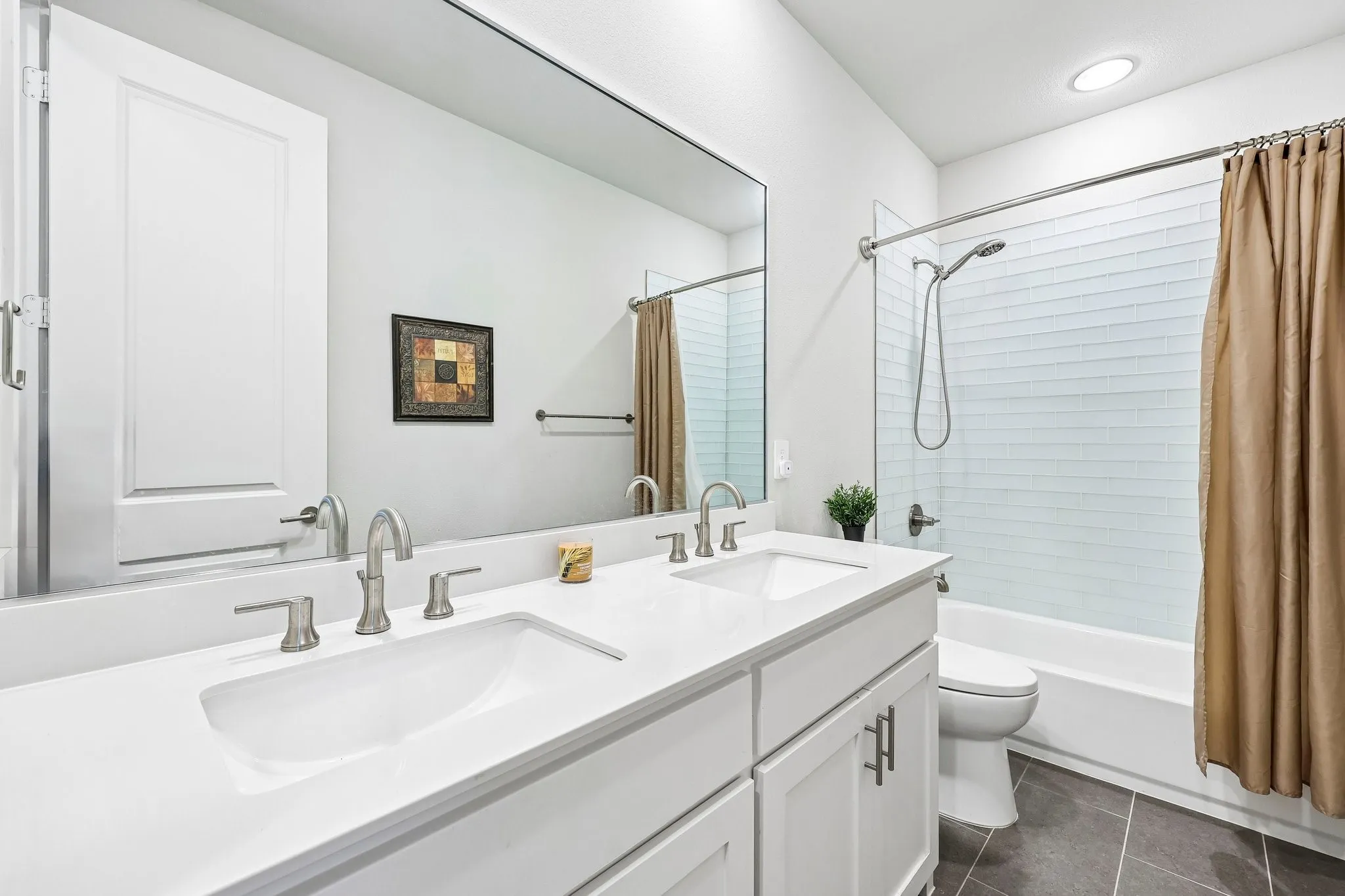 Secondary Bathroom with dual sinks and Bathtub Shower Combo