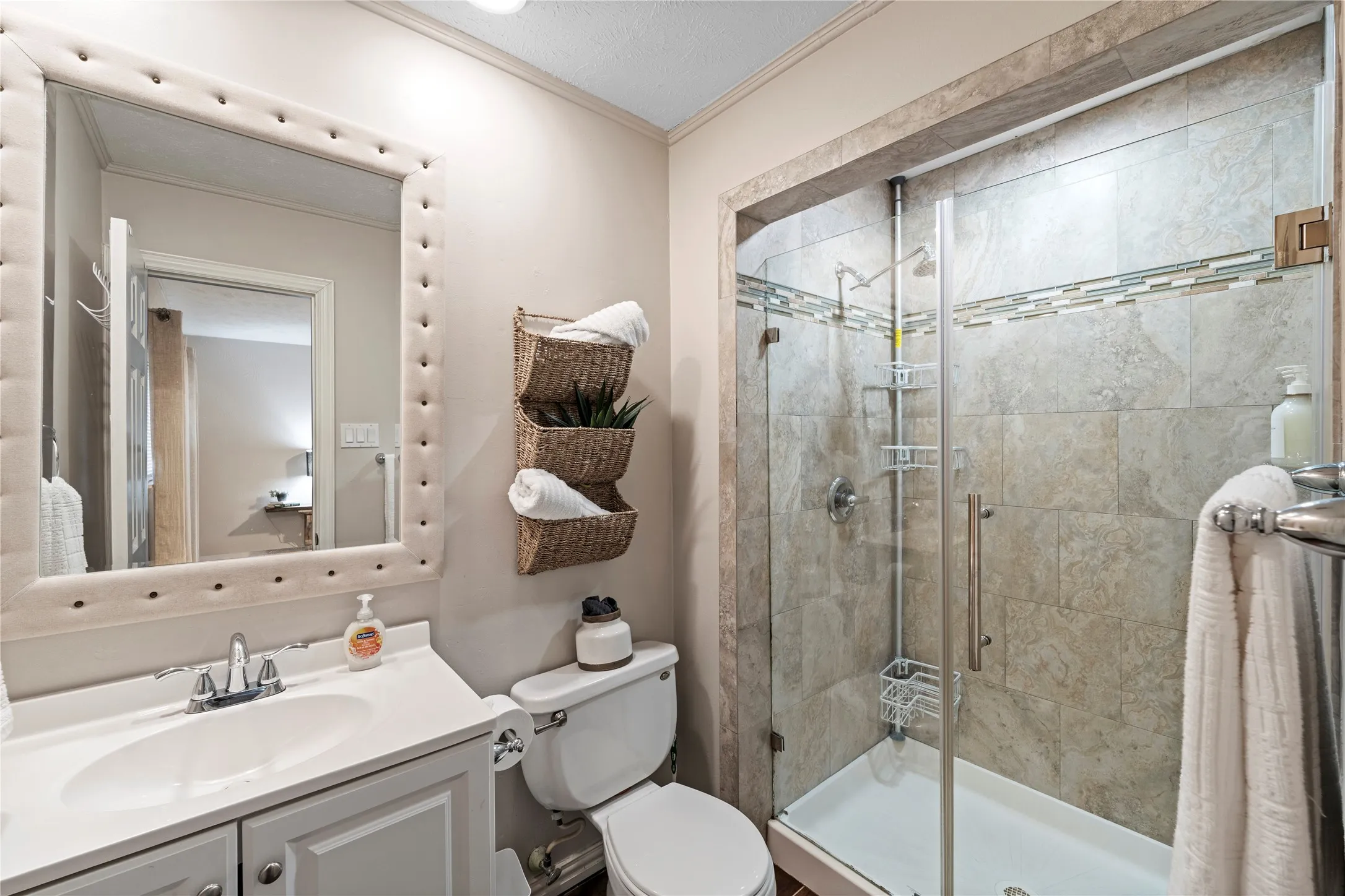 Glass-enclosed shower with tile surround and decorative accent band