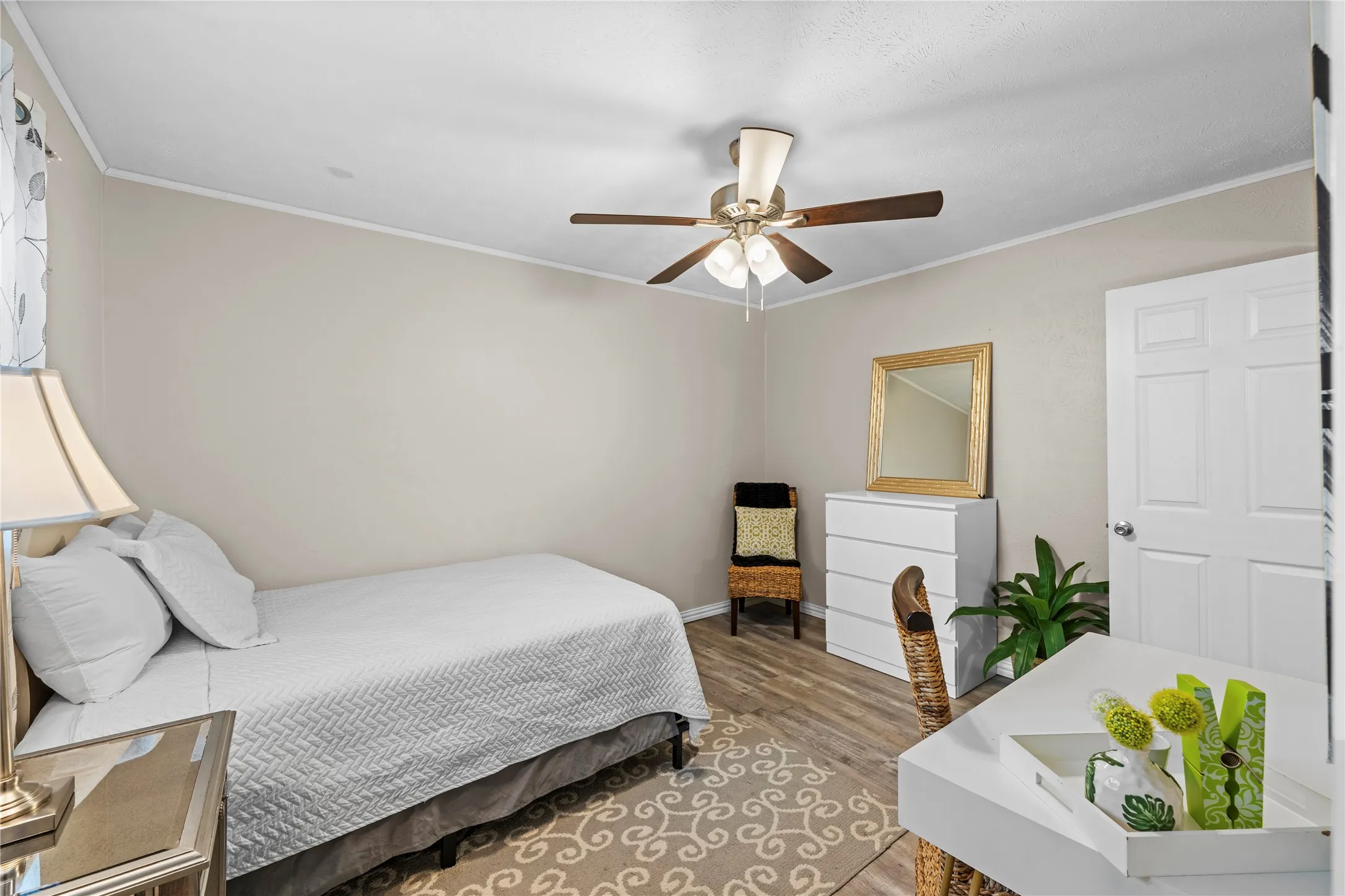 Recessed lighting, ceiling fan with light fixture, wood-finish flooring, paneled interior door, and crown molding