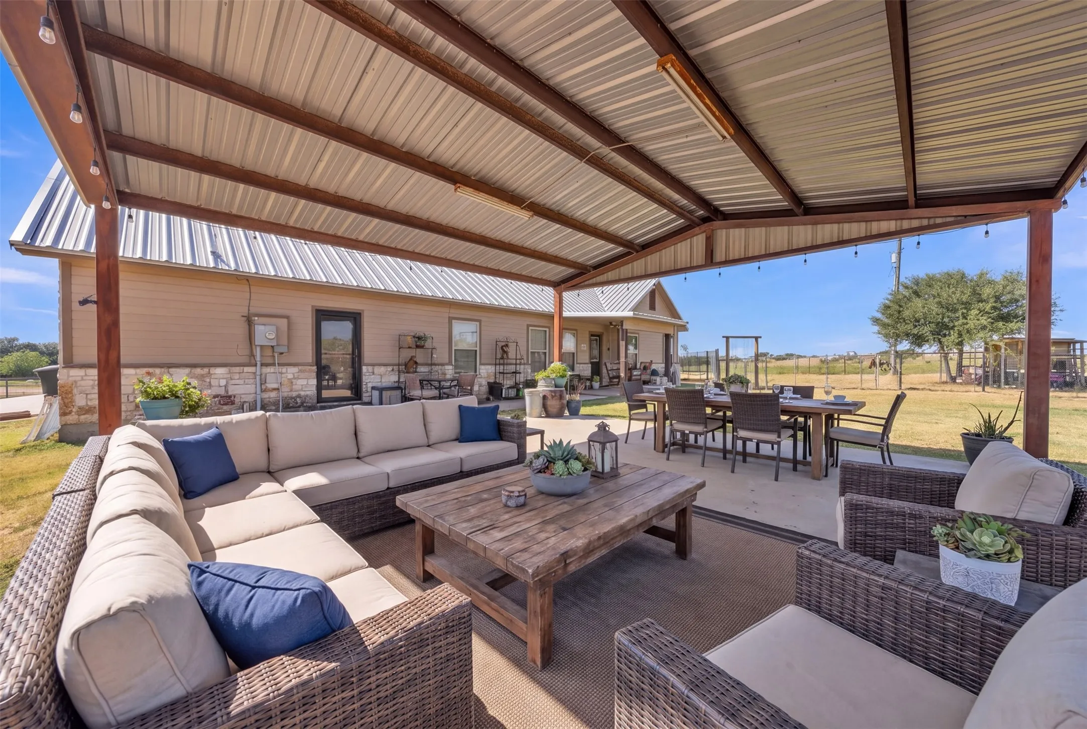 Expansive covered patio featuring a metal roof, string lighting, and direct access to the home