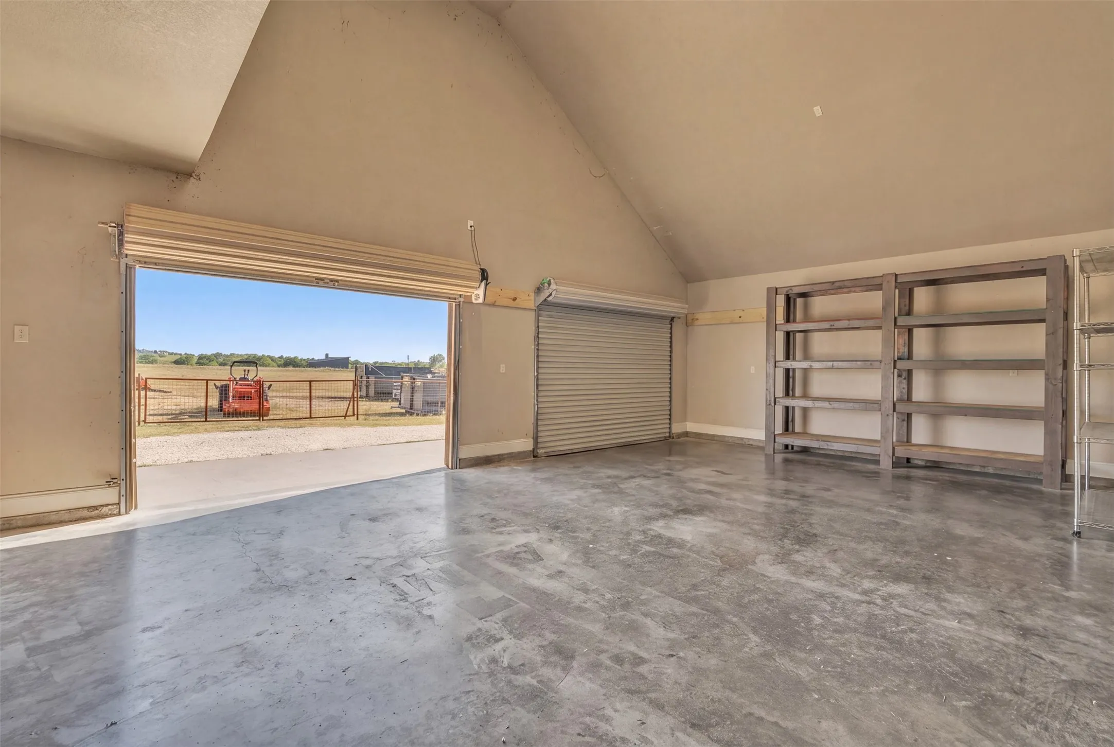 Spacious interior with concrete flooring and sloped ceilings