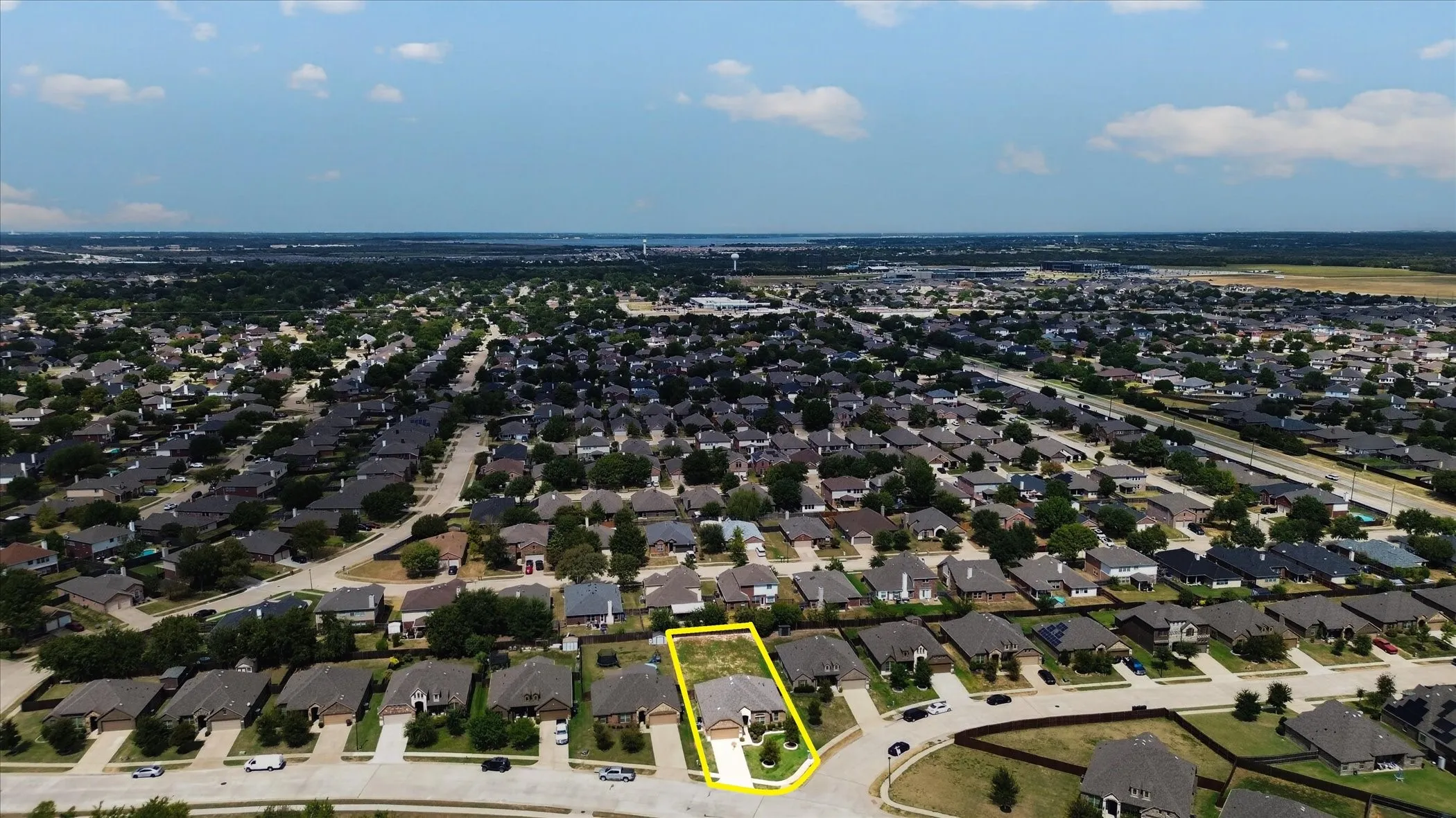 Expansive suburban neighborhood with mature trees and a clear sky backdrop