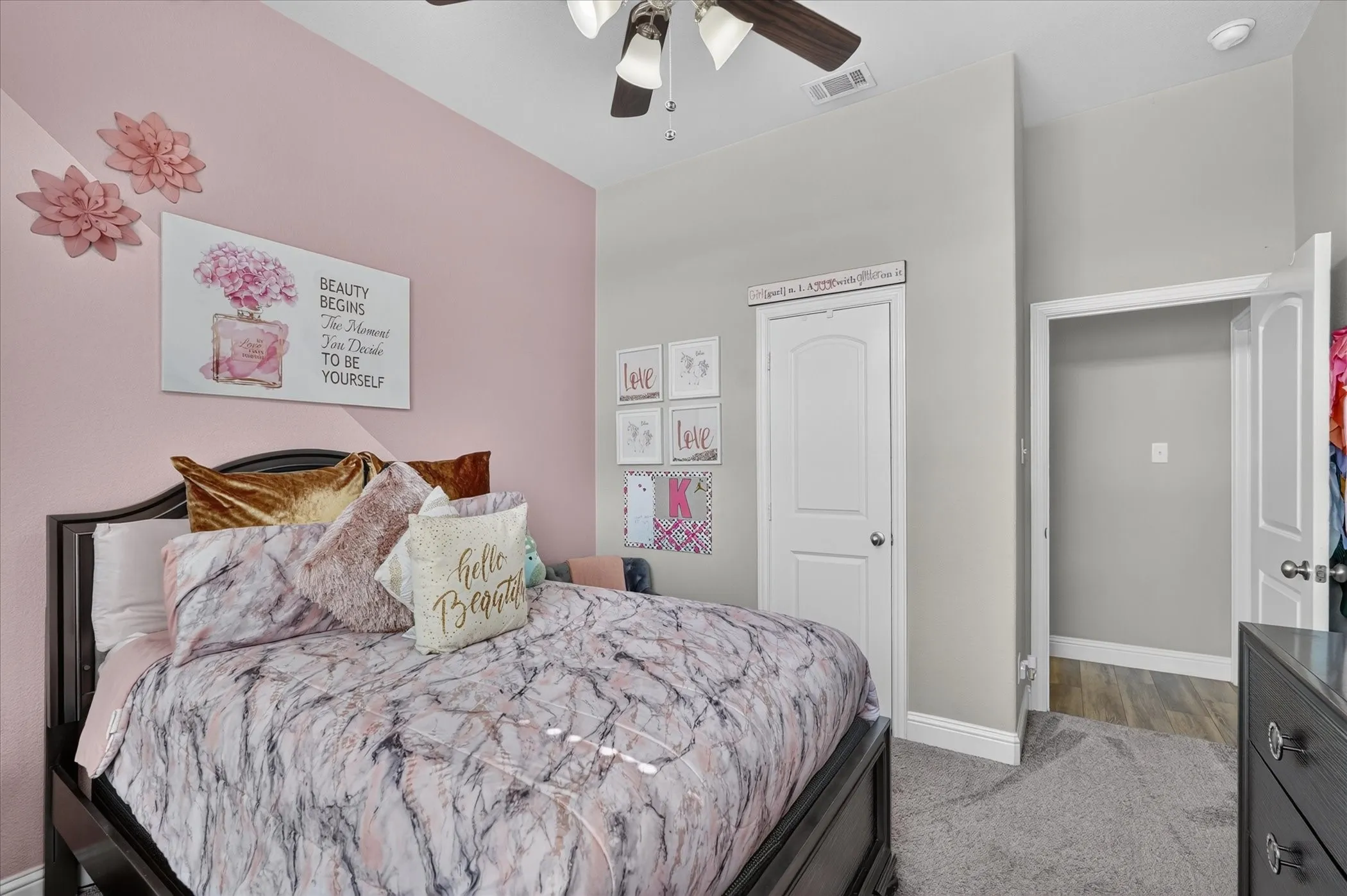 Ceiling fan with light kit, dual-tone wall paint, white interior door, and grey carpet flooring
