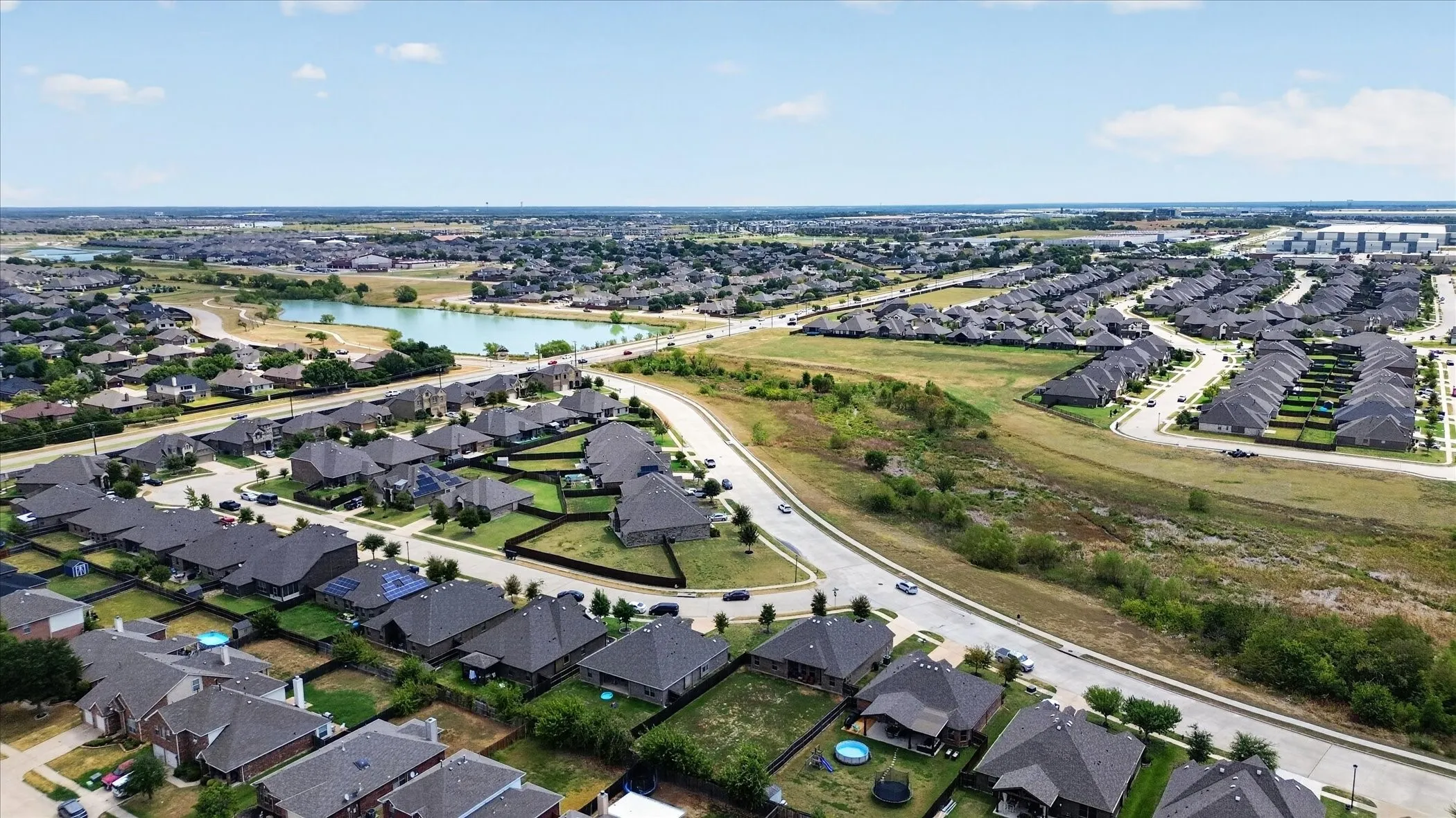 Residential community with a prominent pond and surrounding green spaces