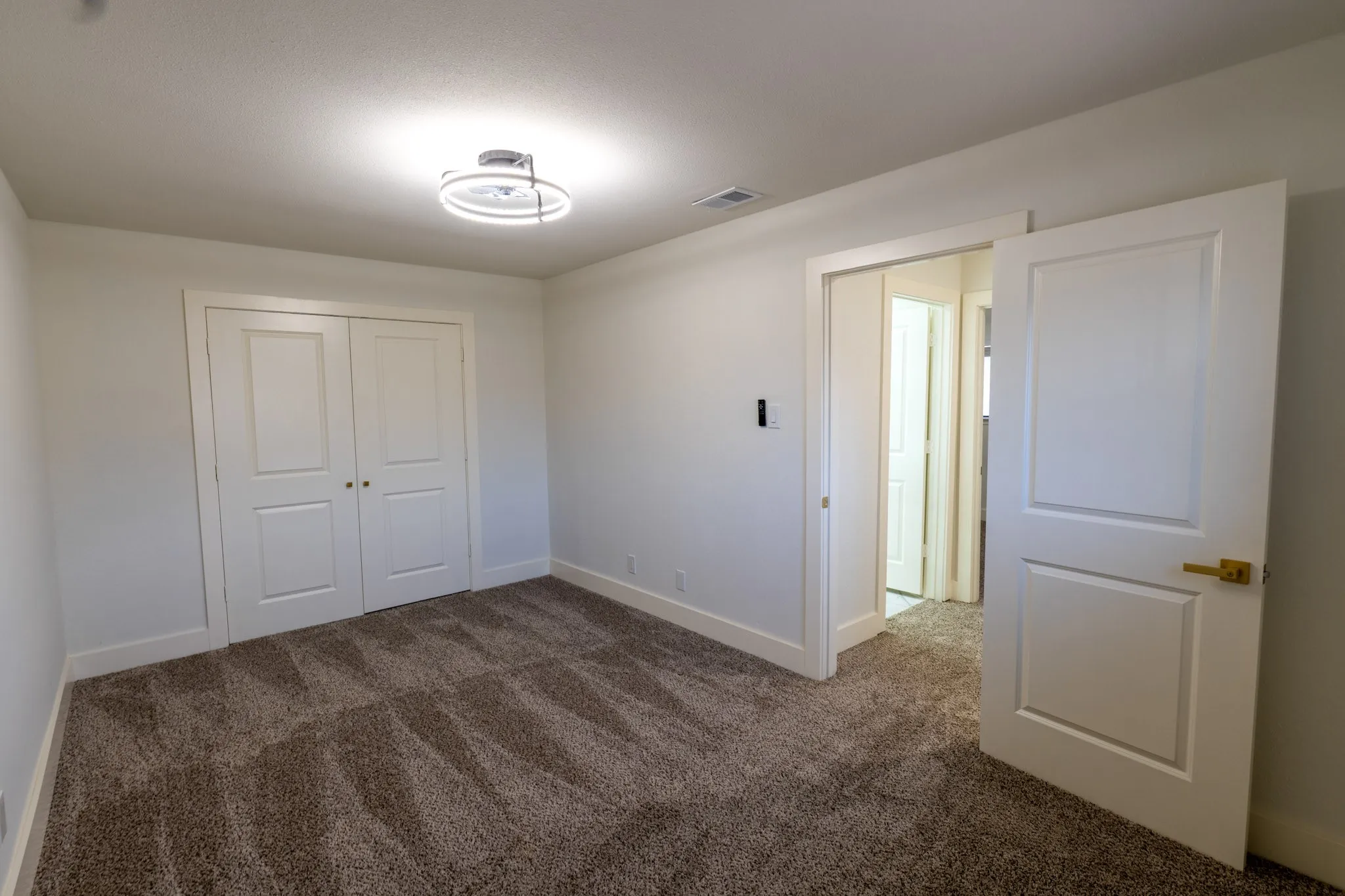 Recessed panel doors, textured carpet flooring, contemporary flush mount lighting, bright white wall finishes, and white trim