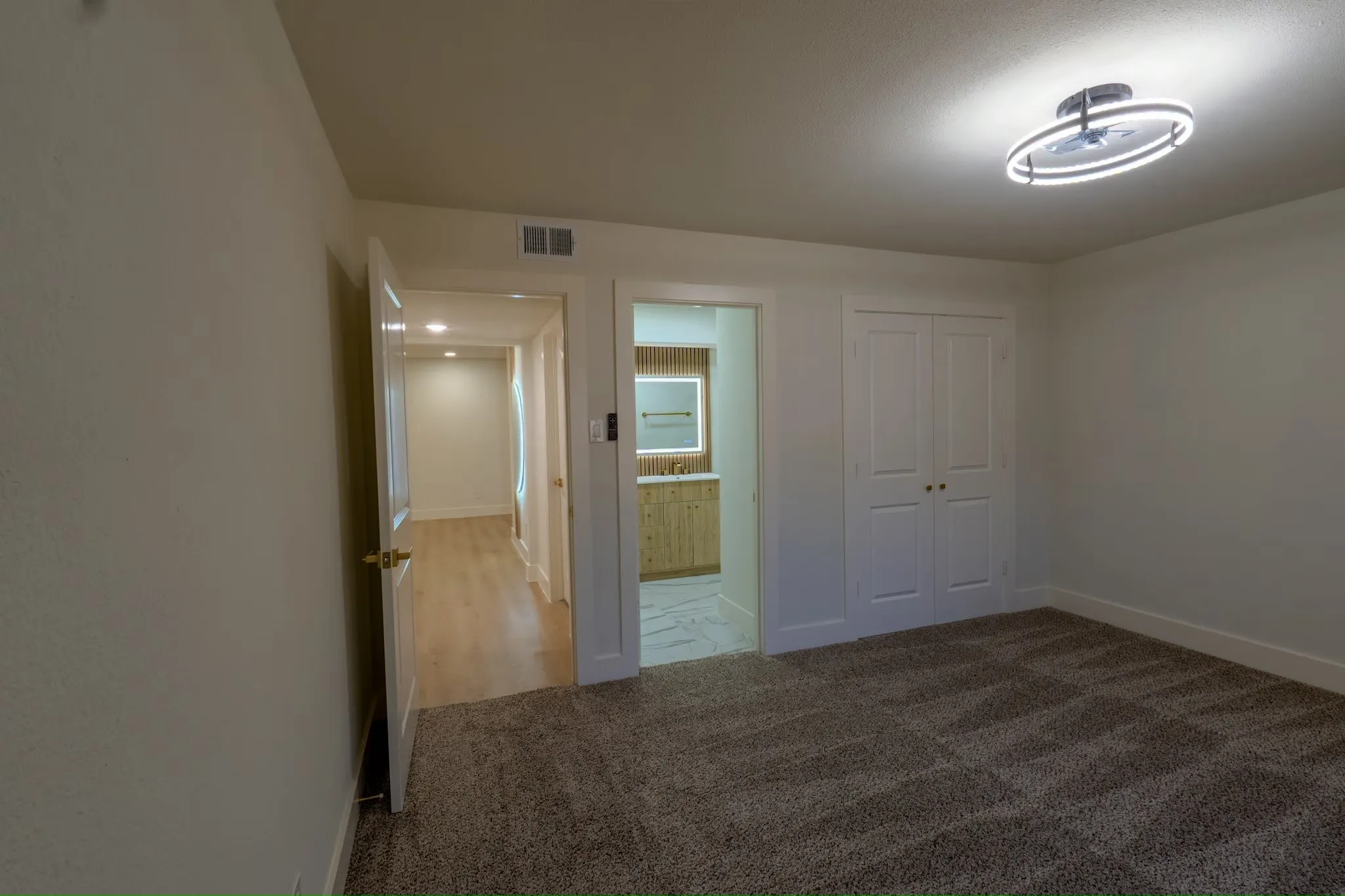 Recessed lighting, contemporary ceiling light fixture, wood-finish flooring, built-in cabinetry, and integrated mirror lighting