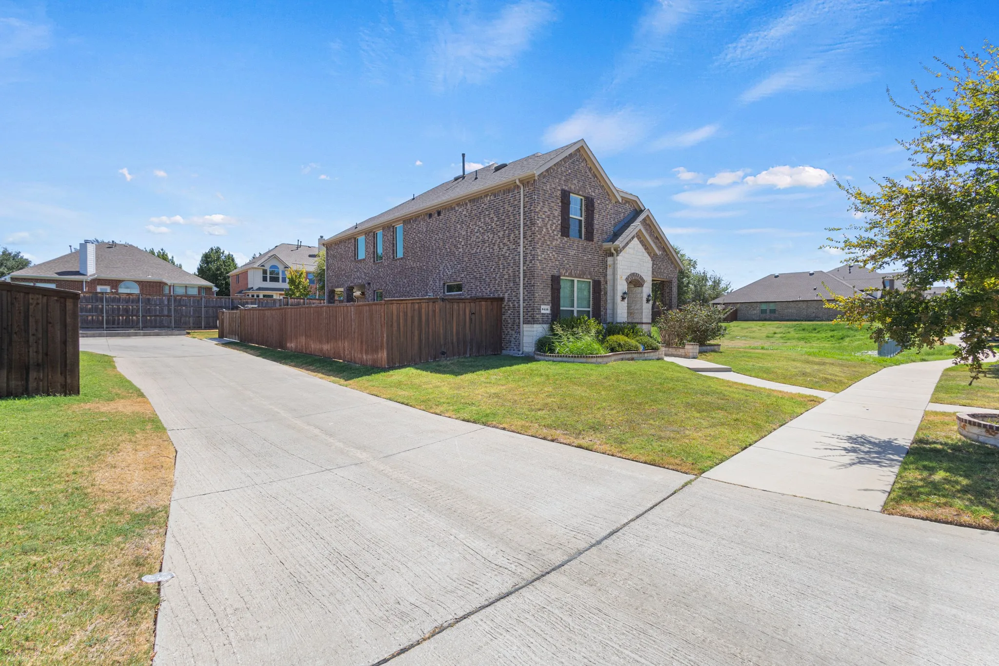 Brick facade residence with a two-story design, attached garage, and a concrete driveway
