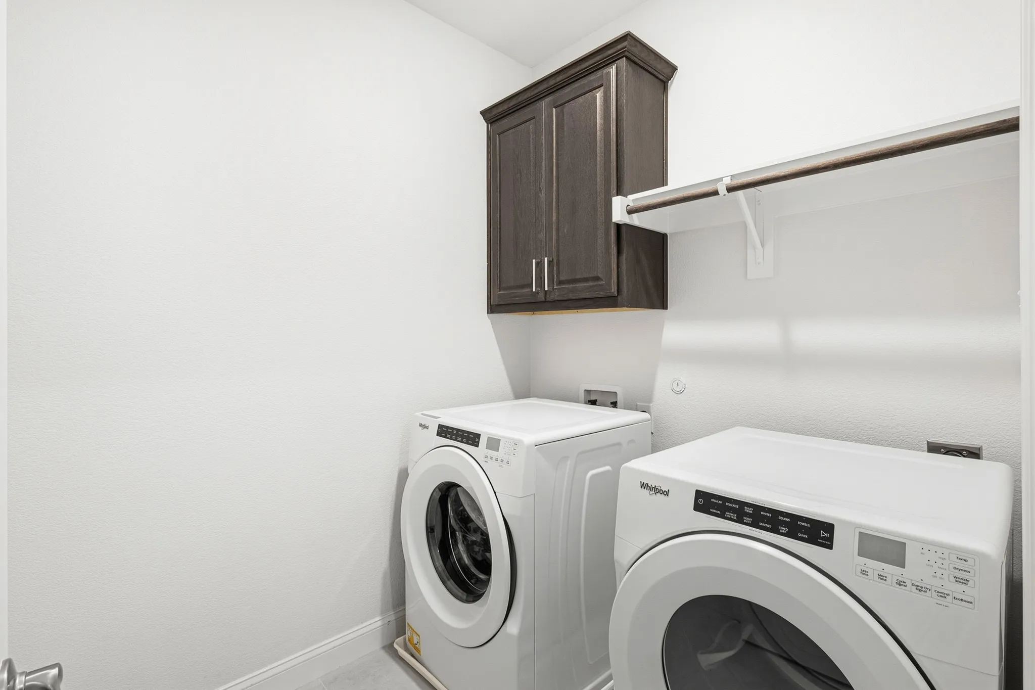 Dark wood-finish cabinetry, white shelving, and a hanging rod