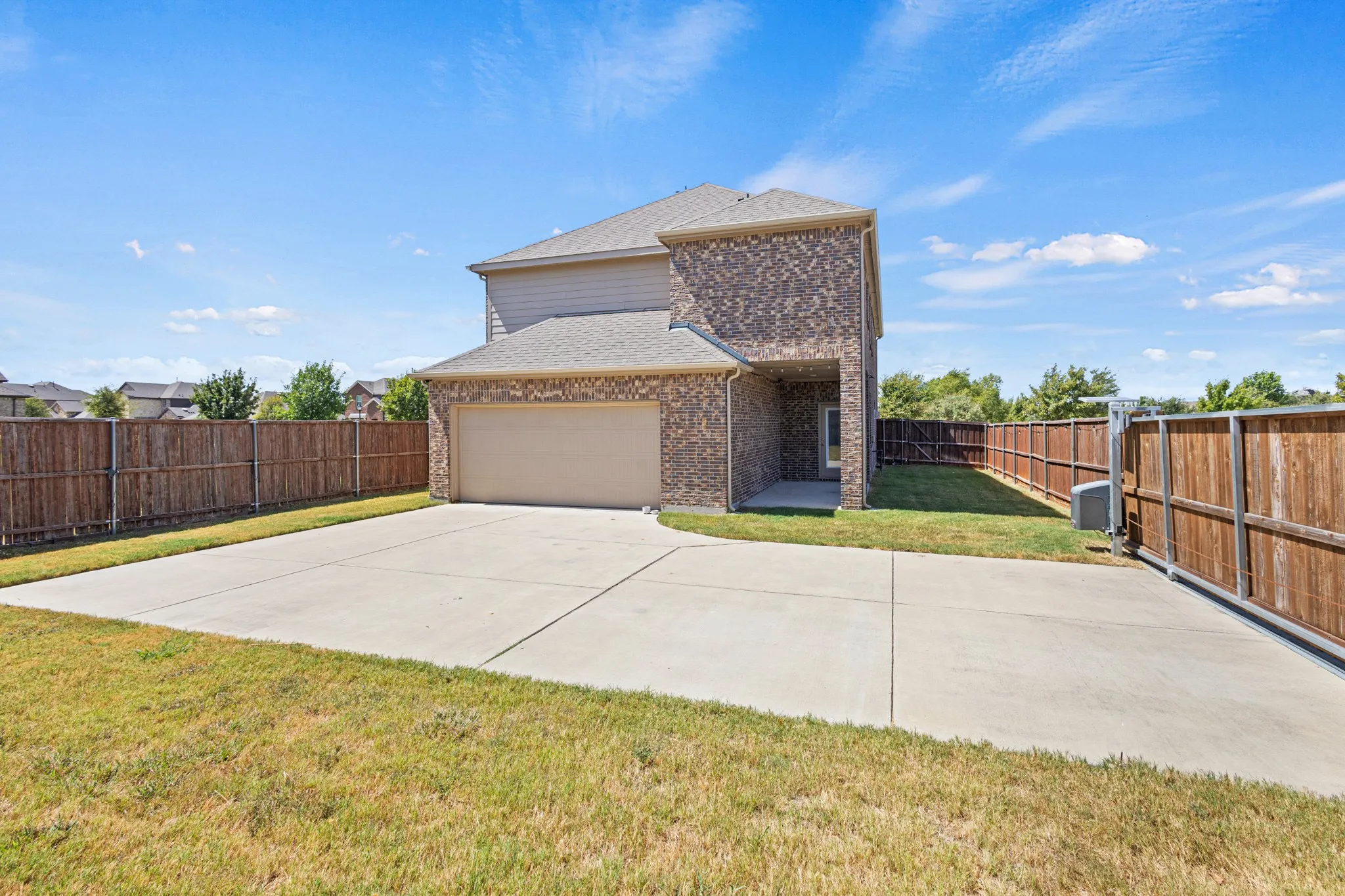 Brick exterior with light-colored siding, attached garage, and concrete driveway