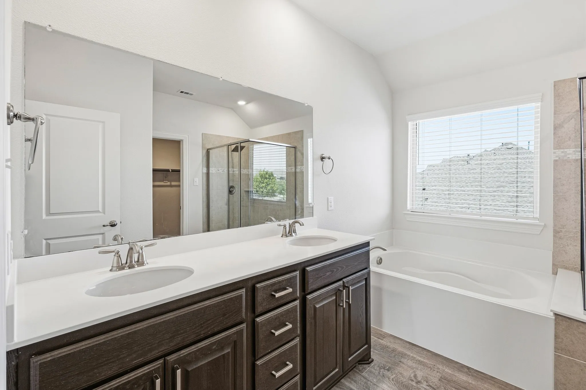 Bathroom featuring a dual vanity with undermount sinks, white countertop, and dark wood-finish cabinetry