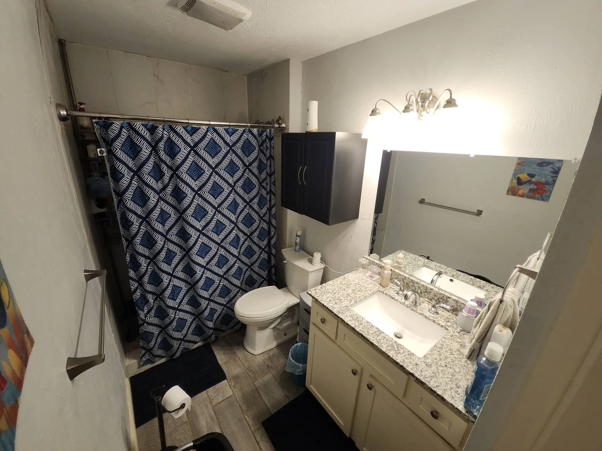 Wood-finish flooring with a vanity featuring a light-colored countertop and integrated sink