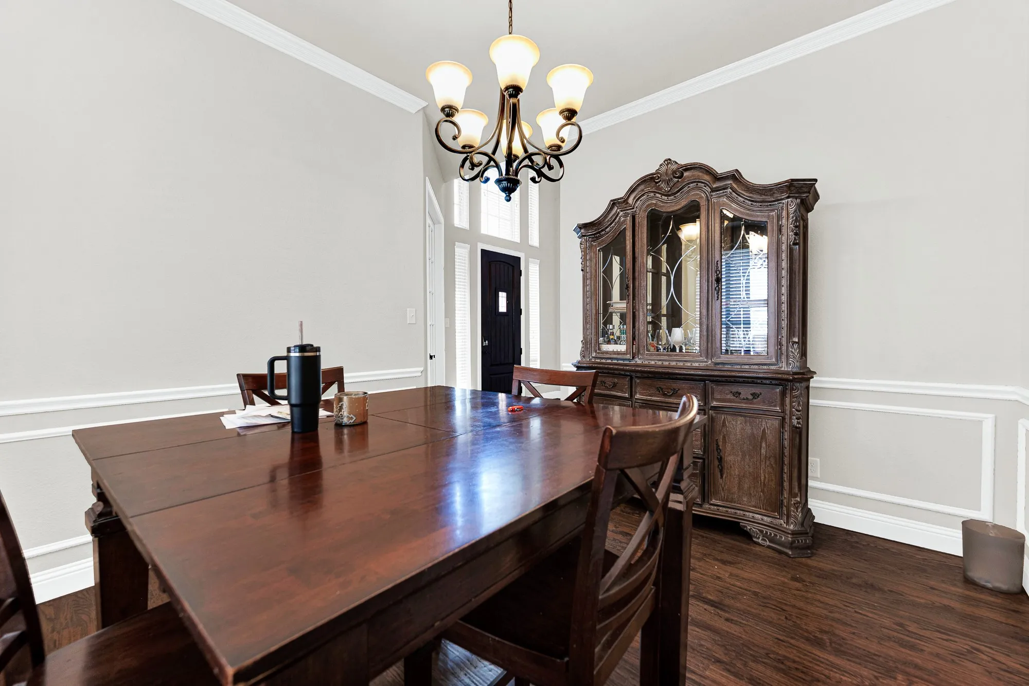The graceful, traditional chandelier acts as a stunning architectural focal point, beautifully balancing the clean lines of the walls and ceiling. Picture setting the table for a memorable Thanksgiving feast, with delicious aromas drifting in from the kitchen.