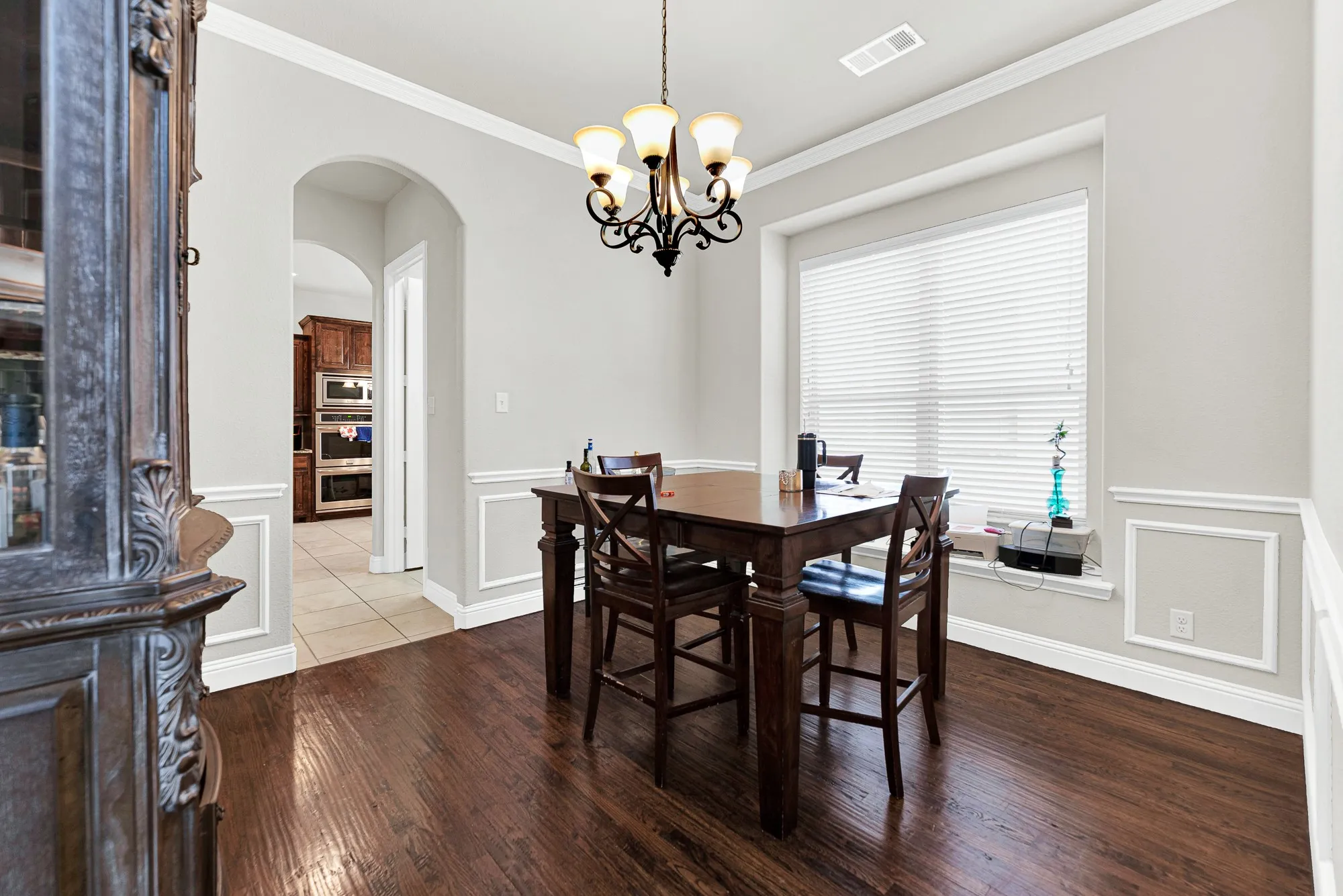 A grand arched opening provides a clear visual connection into the heart of the home, drawing you towards the adjacent living spaces. Imagine casual family game nights at the table, just steps away from the action in the kitchen and great room.