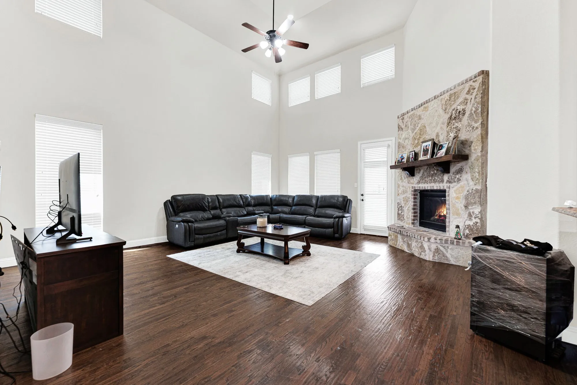 The stone fireplace draws your eyes right up toward the soaring double-height ceilings and cascading natural light. Picture gathering around a crackling fire with loved ones on a chilly winter evening.