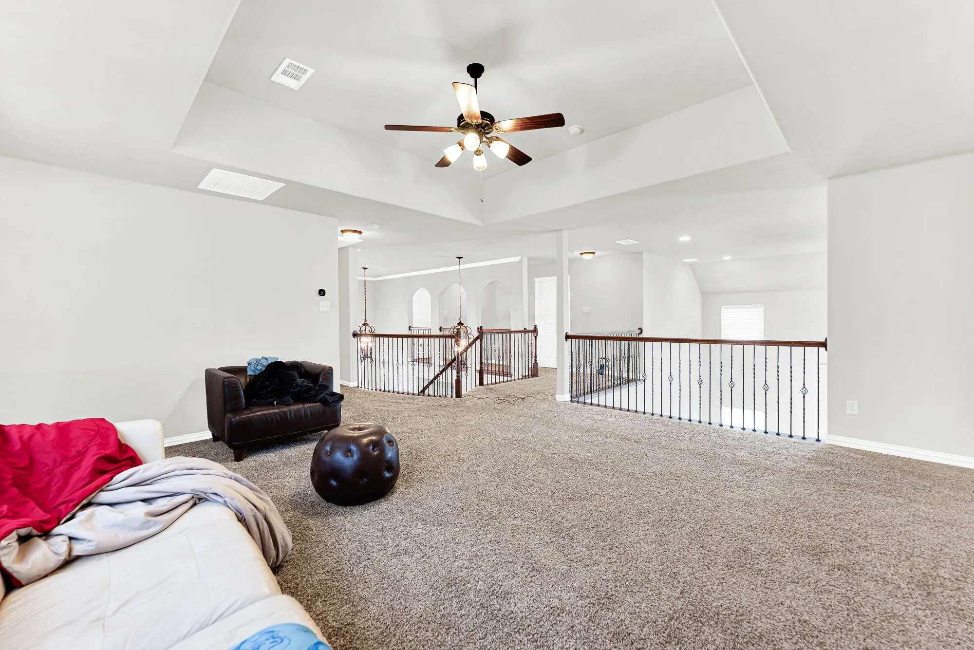 Open wrought-iron railings frame the loft, offering sweeping views down into the entry and main living areas below. It is an ideal setup for keeping the upstairs lively while staying seamlessly connected to the rest of the home.