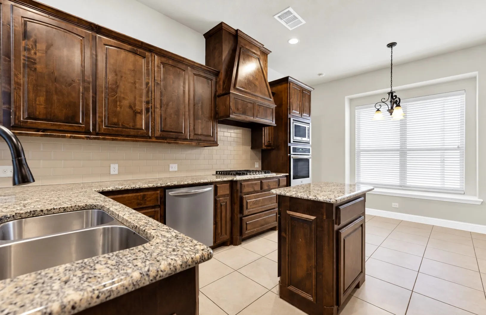 Photo digitally enhanced using AI.  Rich, dark wood cabinets extend almost to the ceiling, grounding the light-filled cooking space. Visualize yourself baking morning treats on the granite counters as soft light streams through the nearby window.