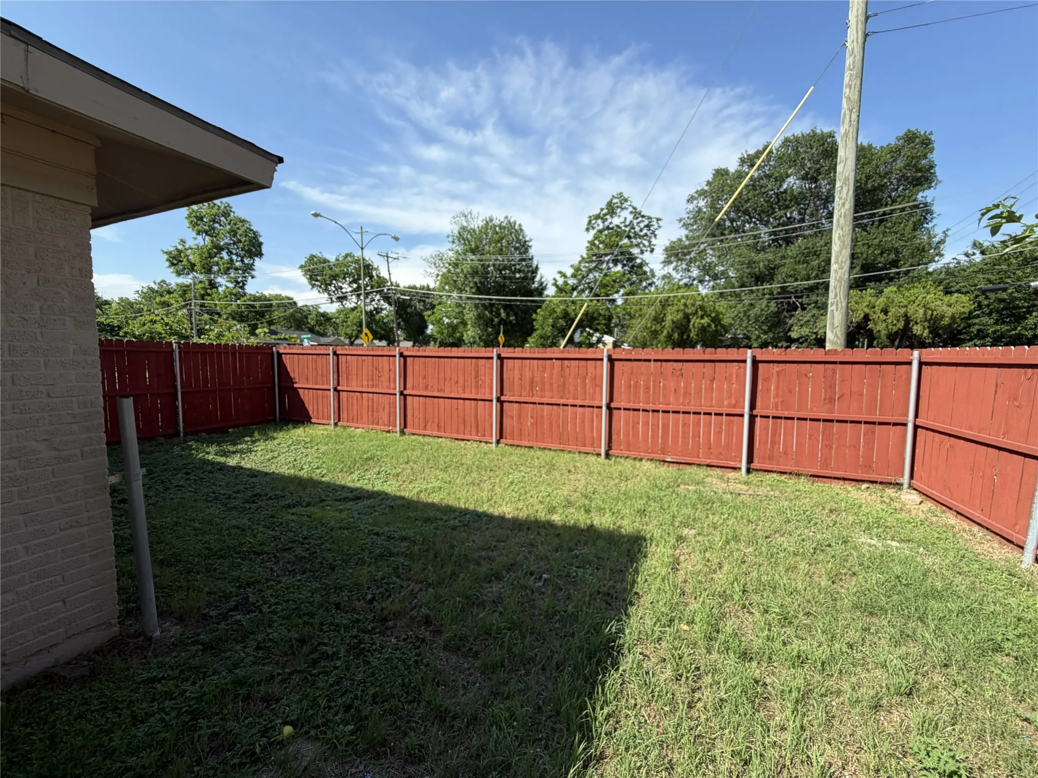 Expansive yard with red-stained privacy fencing