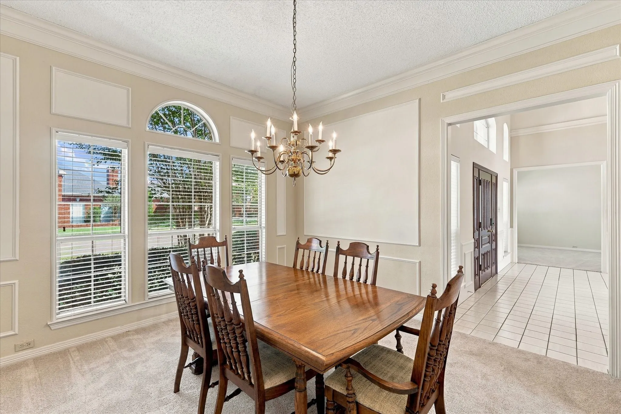Crown molding, decorative wall trim, and a brass chandelier