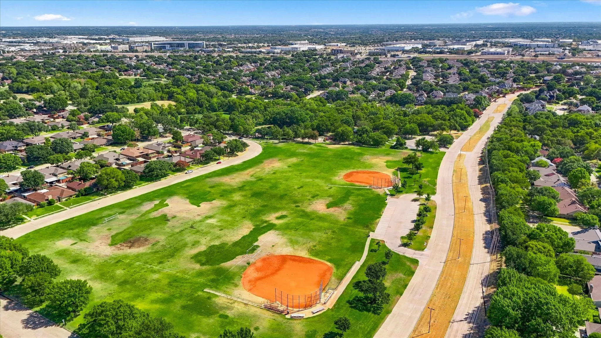 Expansive green space featuring two baseball diamonds