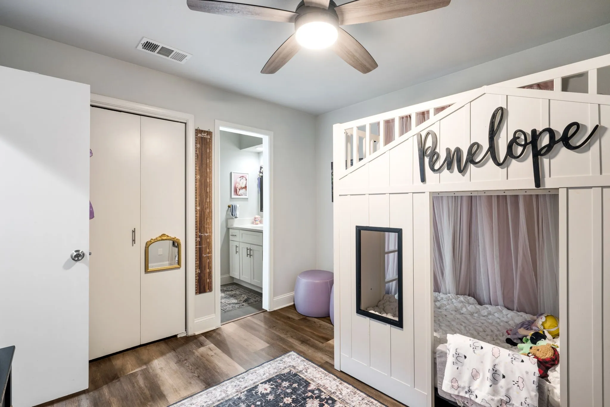 Room featuring wood-finish flooring, a ceiling fan, and a built-in closet with bi-fold doors