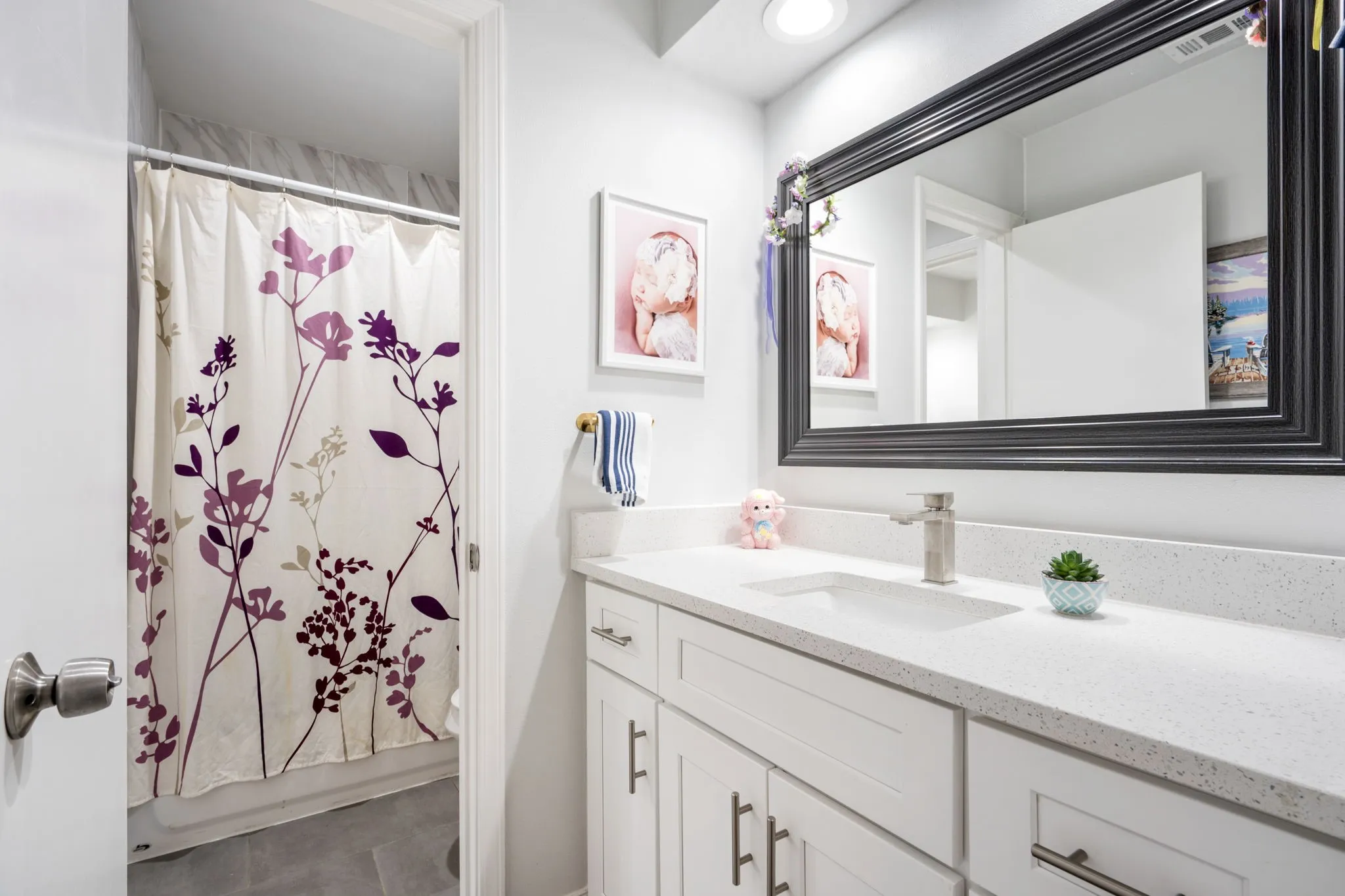 White vanity with ample storage, integrated rectangular sink, and light-toned countertop