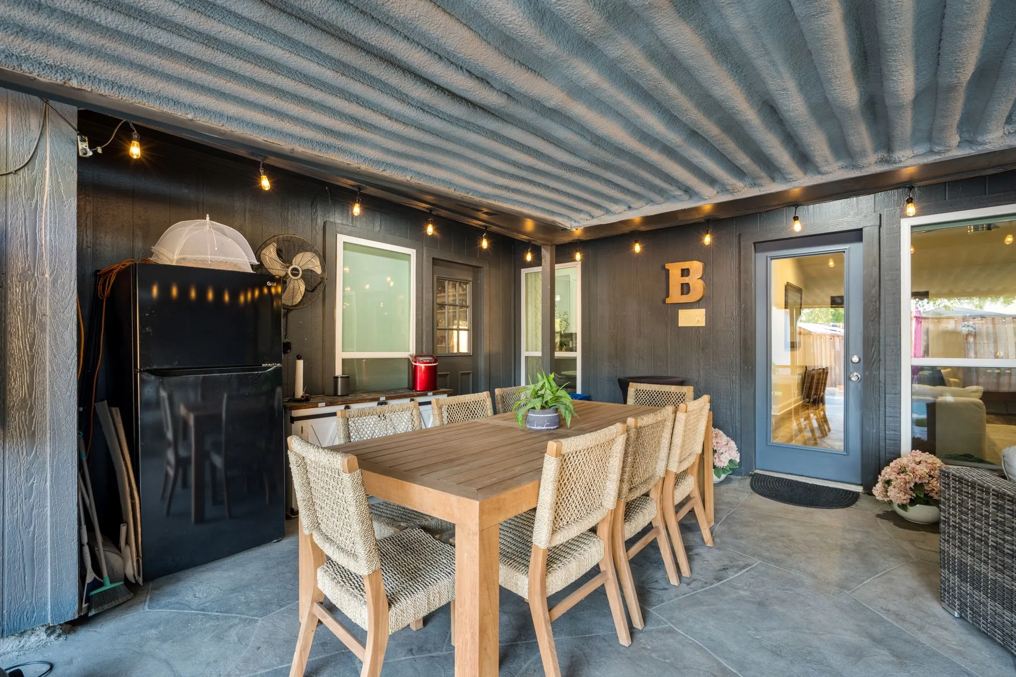 Covered patio featuring a foam insulation ceiling, string lighting, and direct access to interior spaces.  Large enough for full dining set and separate seating area.
