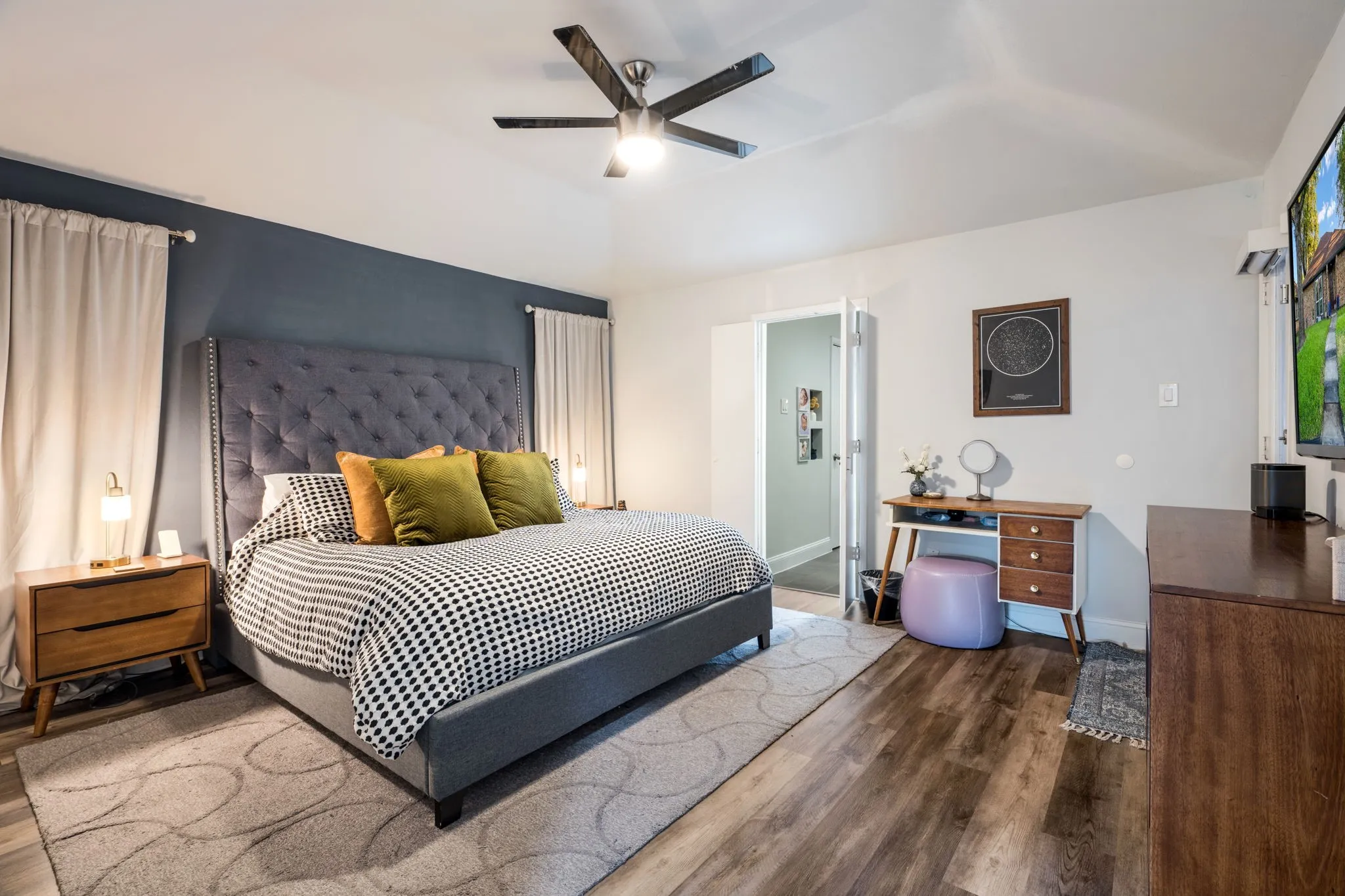 Vaulted ceiling with a ceiling fan, wood-finish flooring, and backyard access