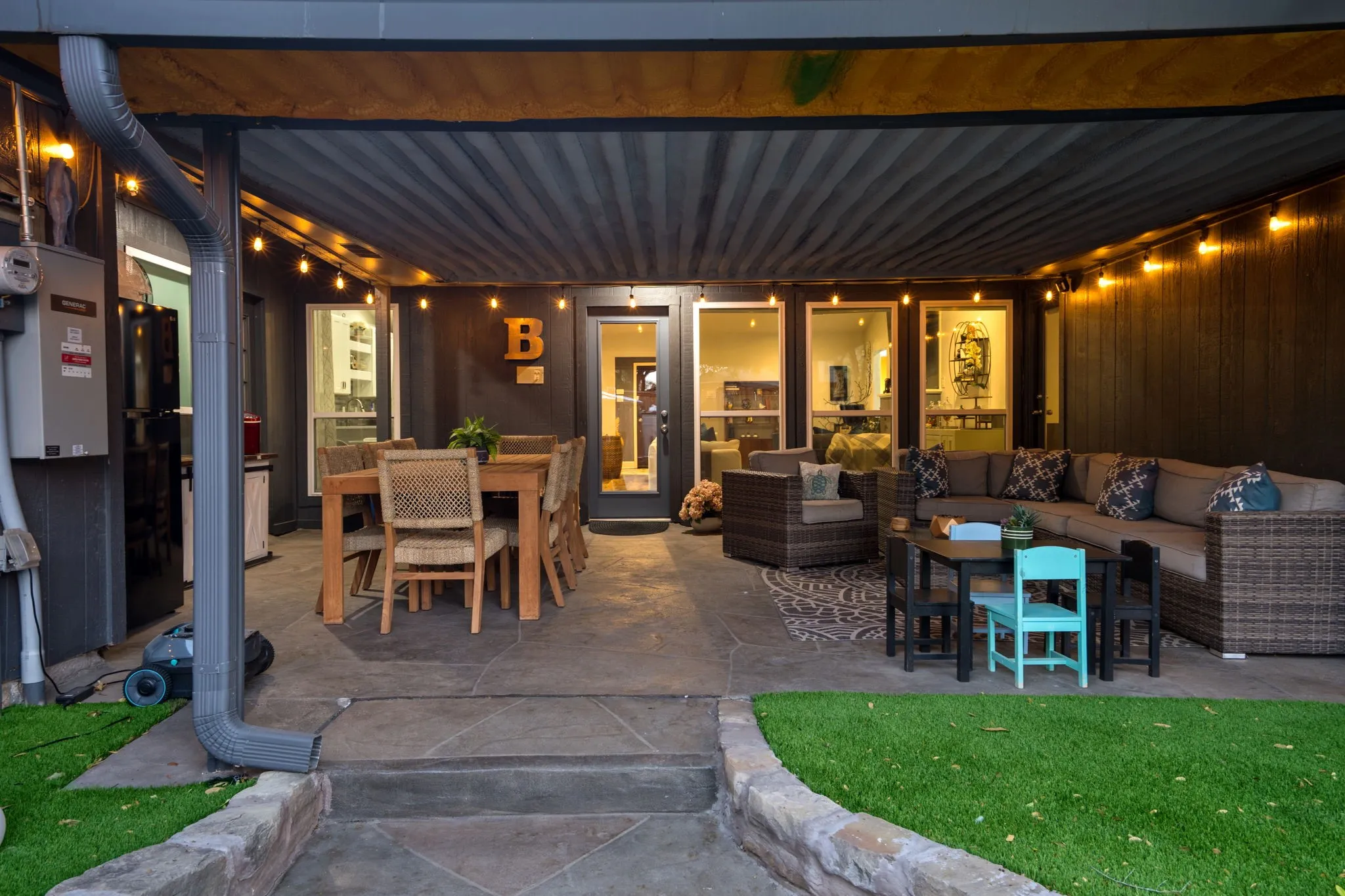 room for eating area and seating area, stamped concrete flooring, string lighting, insulated ceiling, turf