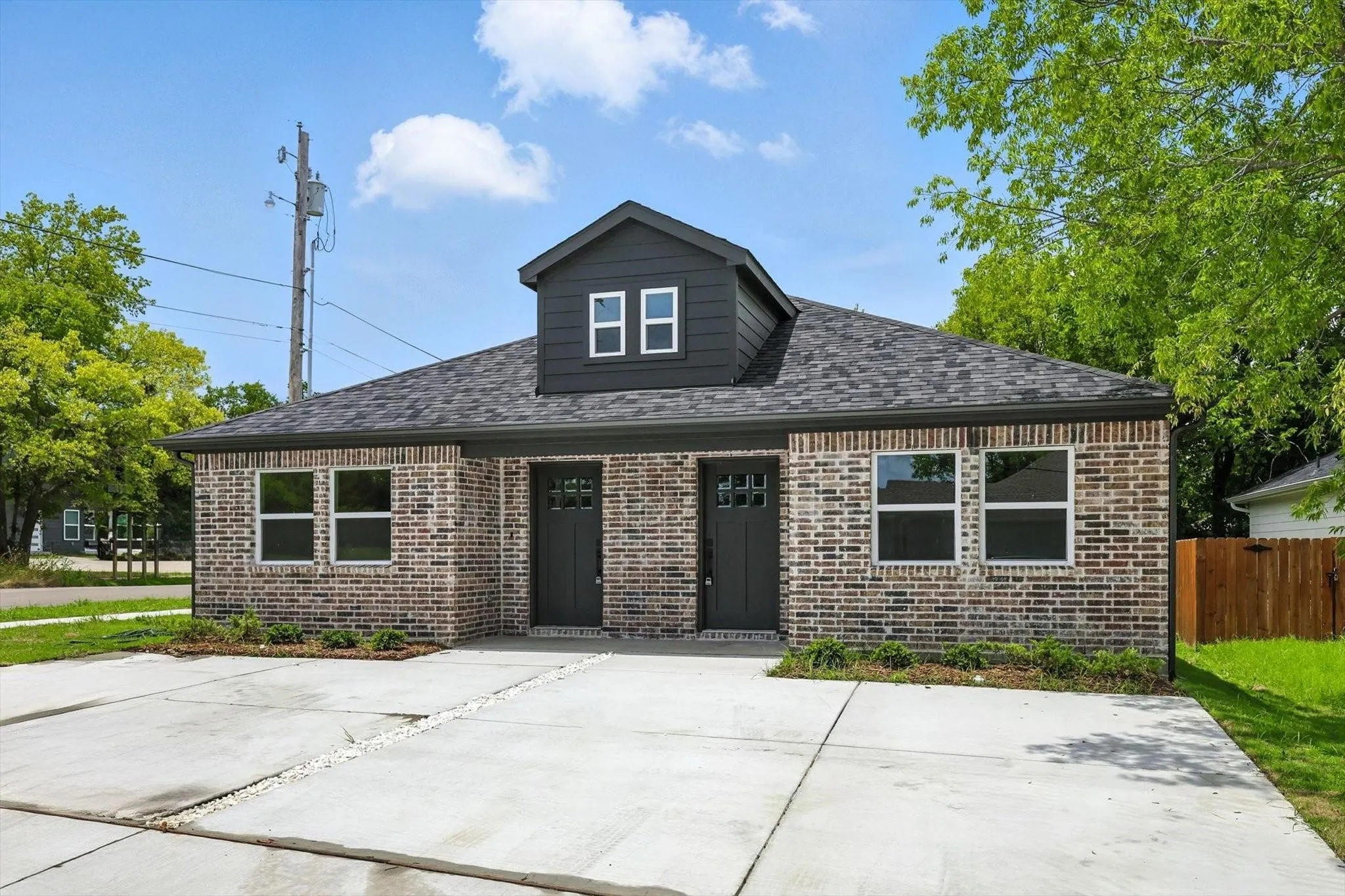 Brick exterior with dark trim and a dormer window