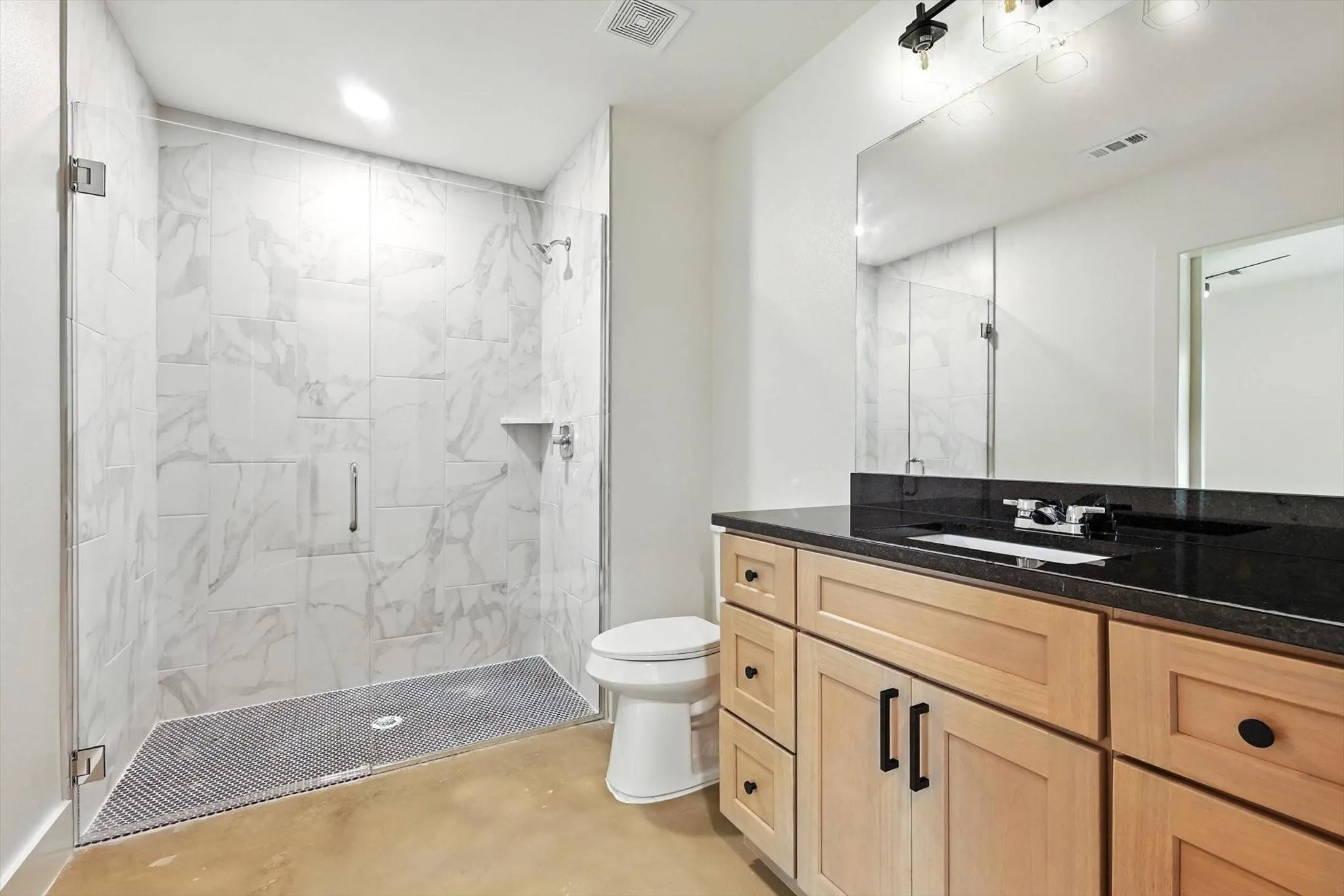 Glass-enclosed shower with subway tile surround and built-in shelf