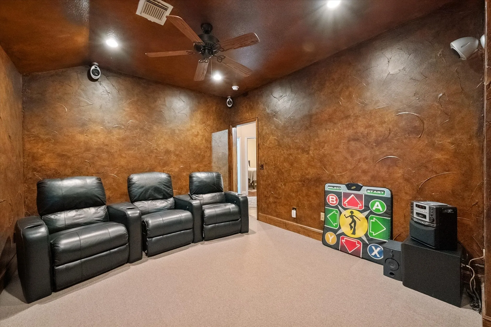 Textured wall finish, recessed lighting, ceiling fan, carpeted flooring, built-in speakers