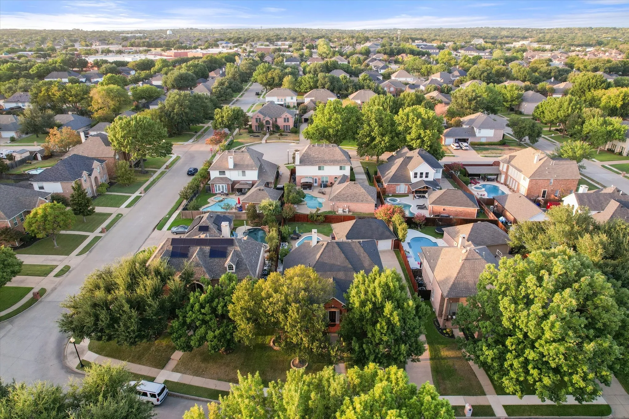 Expansive residential area featuring numerous properties with private swimming pools, mature trees, and established landscaping