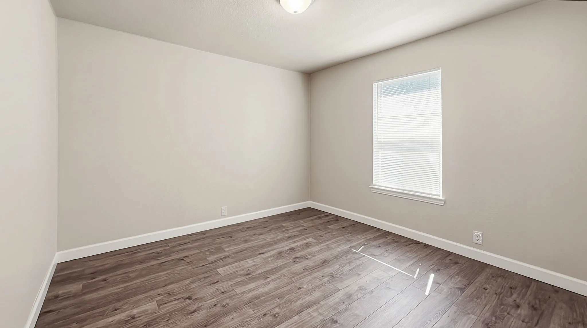 Wood-finish flooring, neutral wall tones, and a window with blinds