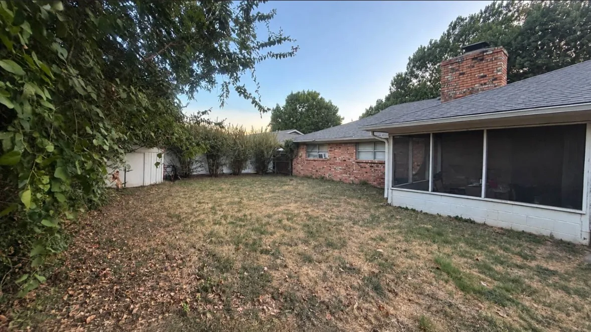 Side view of backyard, very nice and spacious with mature trees.