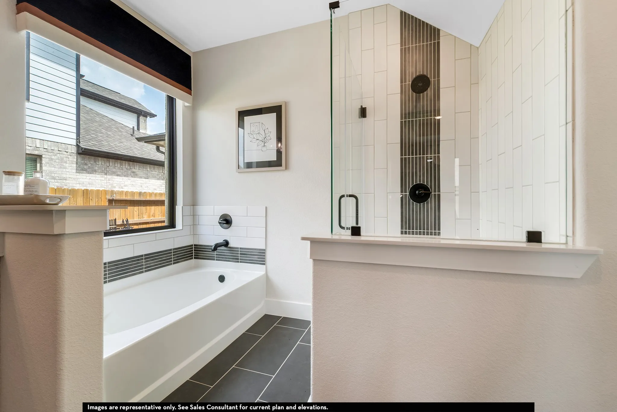 White subway tile bathtub surround with a contrasting gray accent band and matte black fixtures